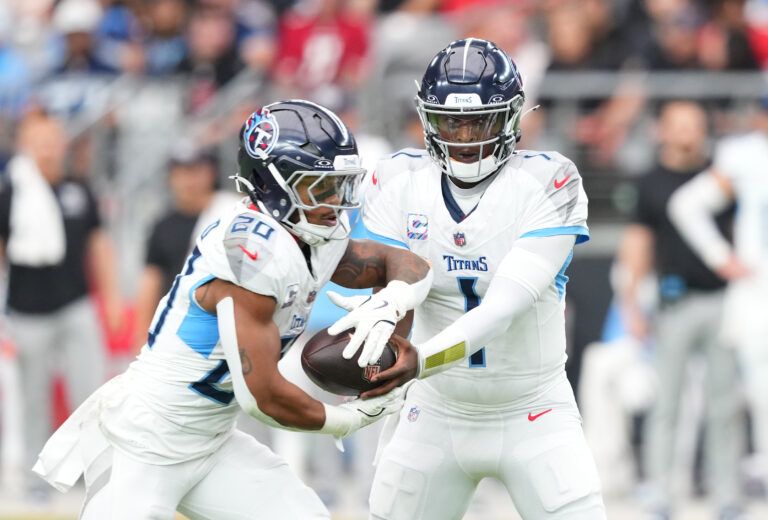 Tennessee Titans quarterback Cam Ward (1) hands off to running back Tony Pollard (20) against the Arizona Cardinals during the first quarter at State Farm Stadium.