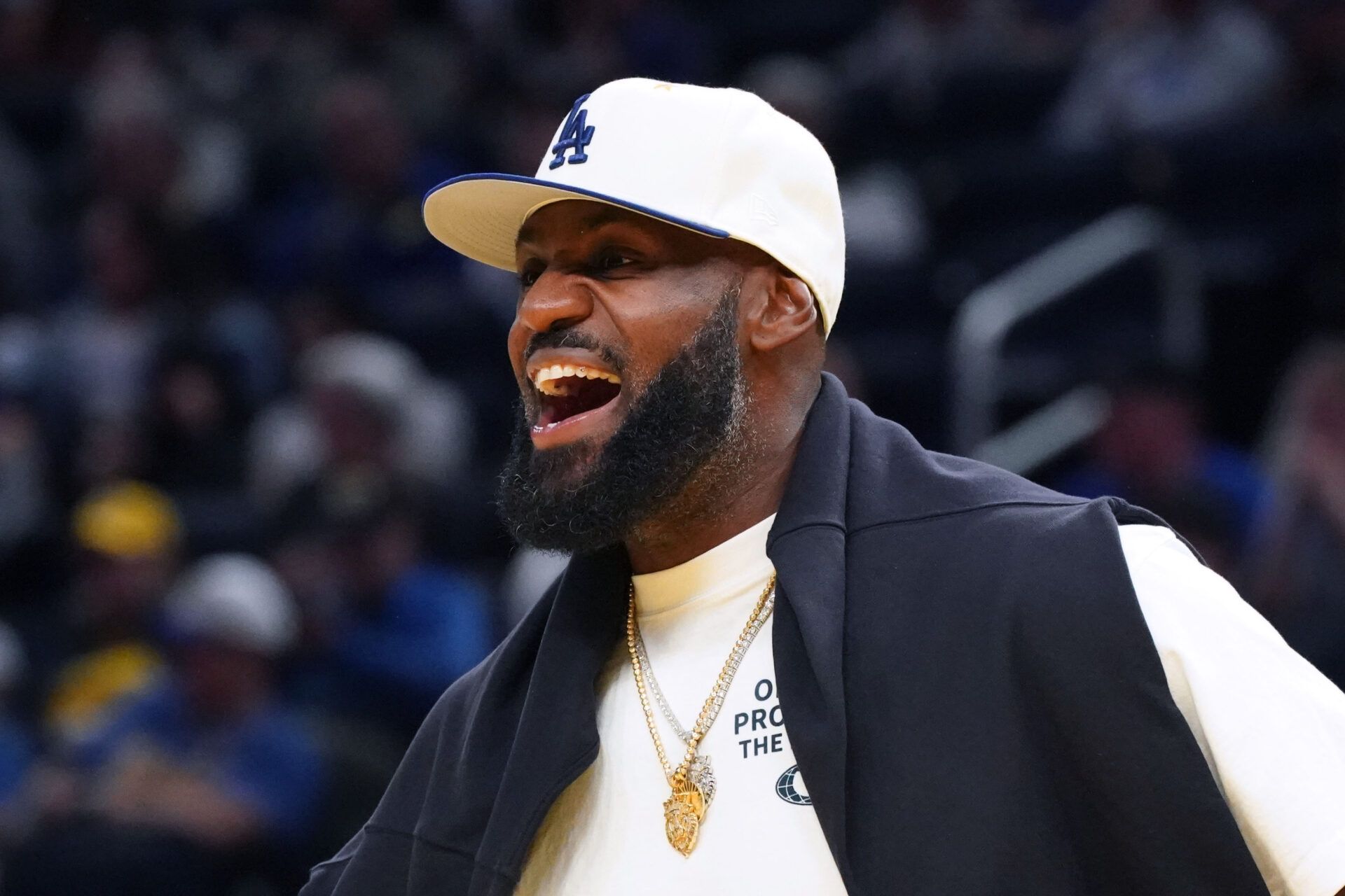 Los Angeles Lakers forward LeBron James (23), wearing a Los Angeles Dodgers hat, watches from the sideline during a break against the Golden State Warriors in the third quarter at Chase Center.