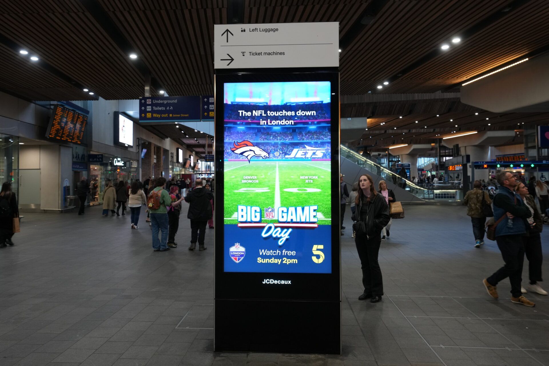 An advertisement for the 2025 NFL London Game between the Denver Broncos and New York Jets at the London Bridge national railway station.