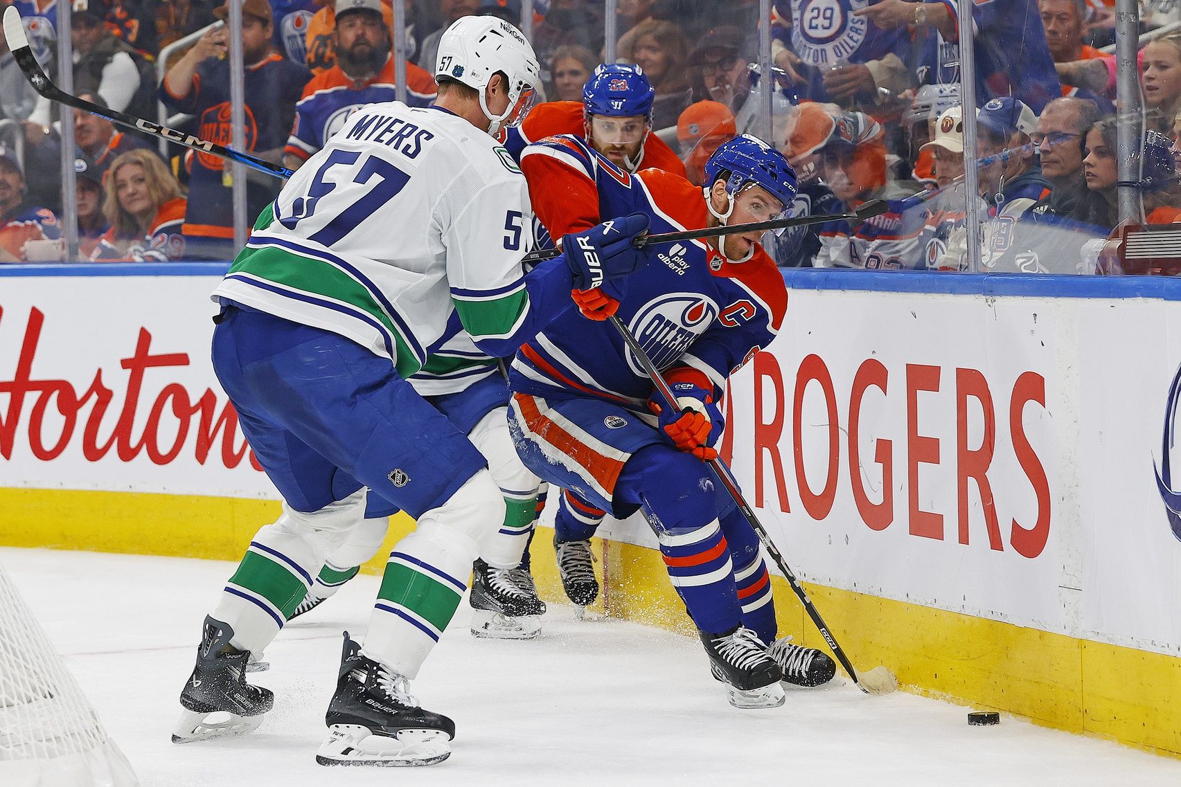 Edmonton Oilers /forward Connor McDavid (97) and Vancouver Canucks defensemen Tyler Myers (57) battle along the boards for a loose puck during the third period at Rogers Place.