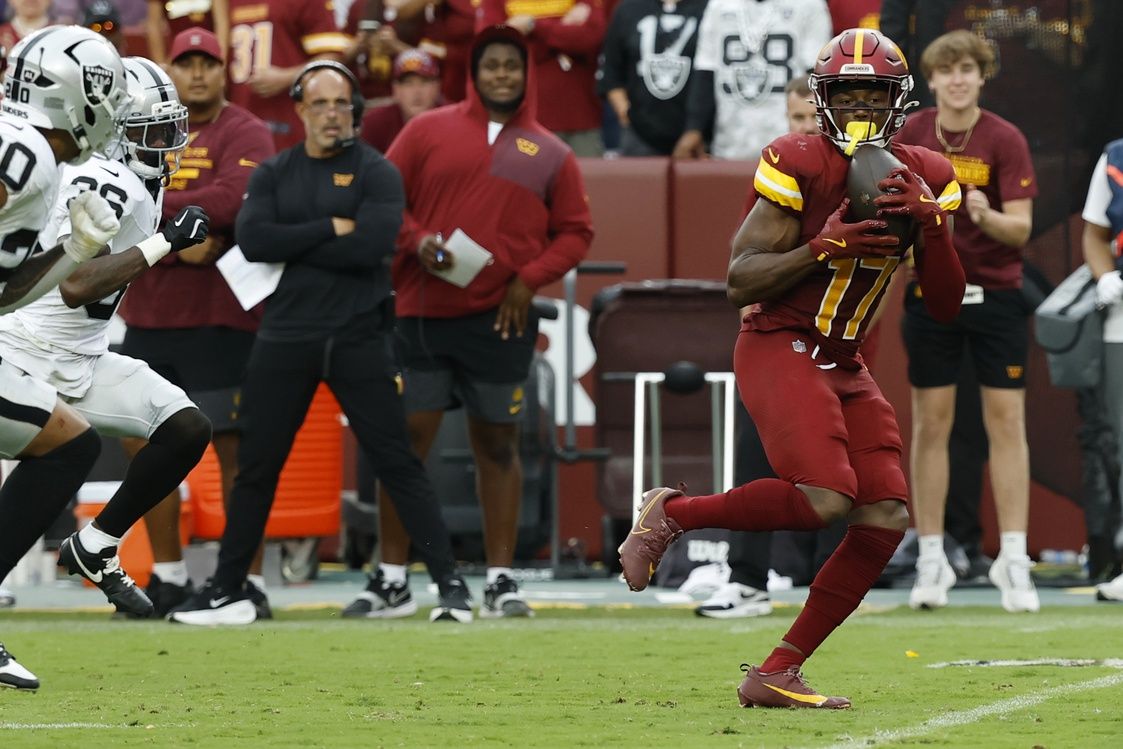 Washington Commanders wide receiver Terry McLaurin (17) catches a pass as Las Vegas Raiders cornerback Kyu Blu Kelly (36) and Raiders safety Isaiah Pola-Mao (20) chase during the third quarter at Northwest Stadium.