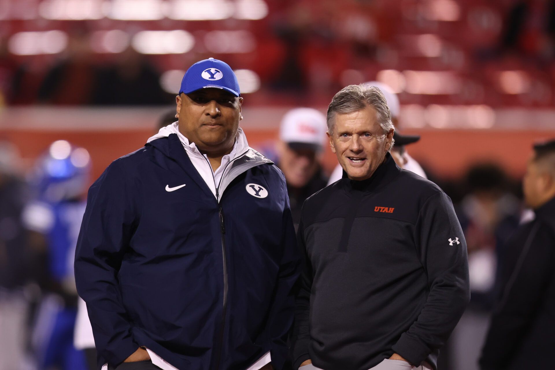Brigham Young Cougars head coach Kalani Sitake (left) and Utah Utes head coach Kyle Whittingham speak before a game at Rice-Eccles Stadium.