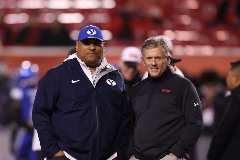 Brigham Young Cougars head coach Kalani Sitake (left) and Utah Utes head coach Kyle Whittingham speak before a game at Rice-Eccles Stadium.