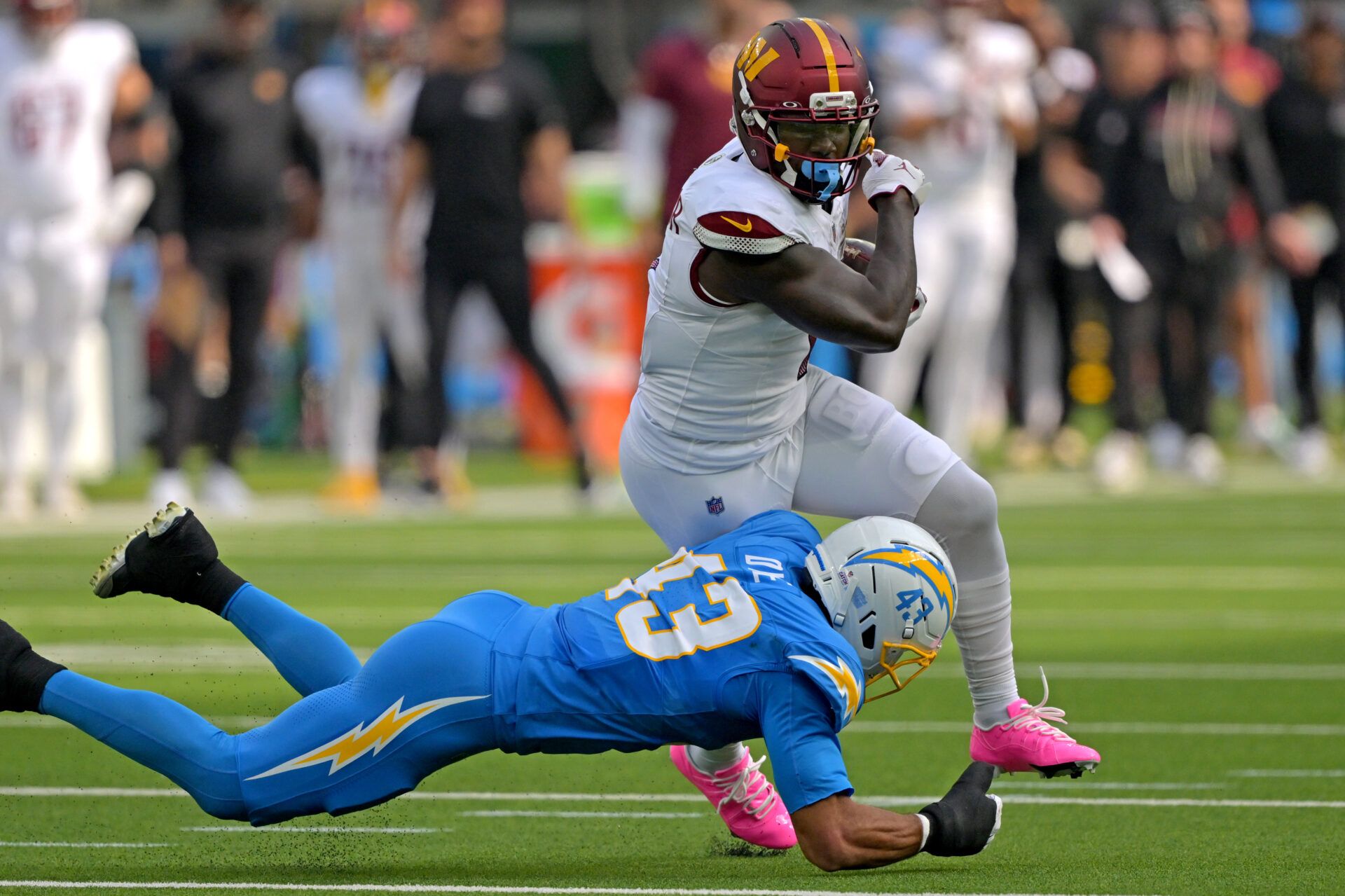 Washington Commanders wide receiver Deebo Samuel Sr. (1) is stopped by Los Angeles Chargers linebacker Troy Dye (43) after a gain at SoFi Stadium.