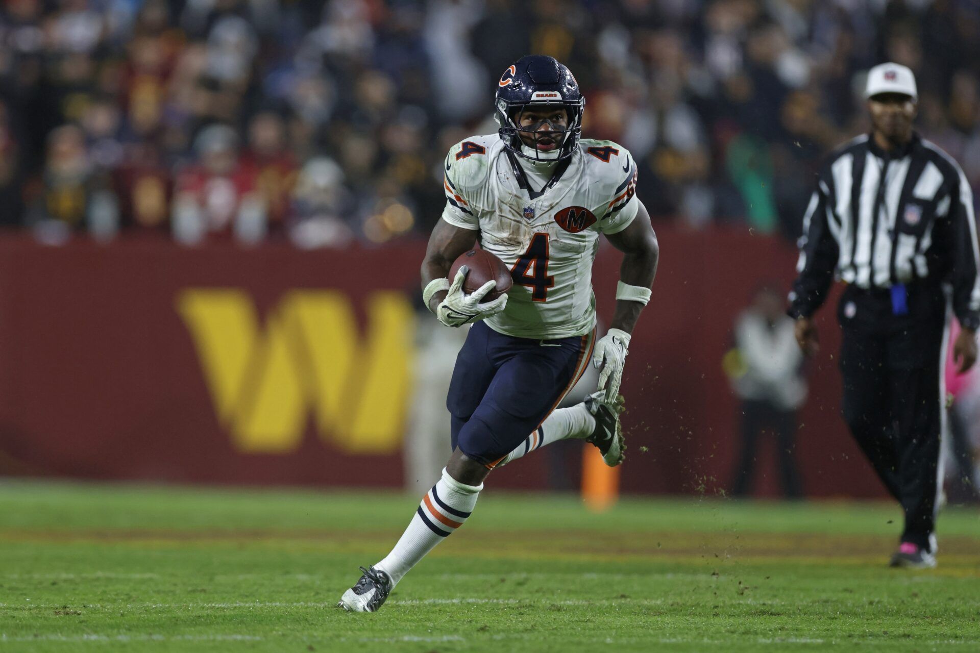 Chicago Bears running back D'Andre Swift (4) runs with the ball against the Washington Commanders during the fourth quarter at Northwest Stadium.