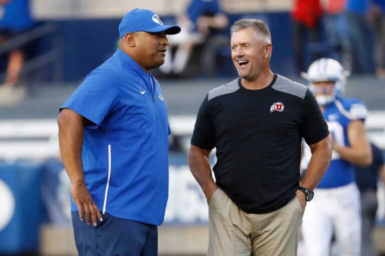Brigham Young Cougars head coach Kalani Sitake, left and Utah Utes head coach Kyle Whittingham get together prior to their game at LaVell Edwards Stadium.