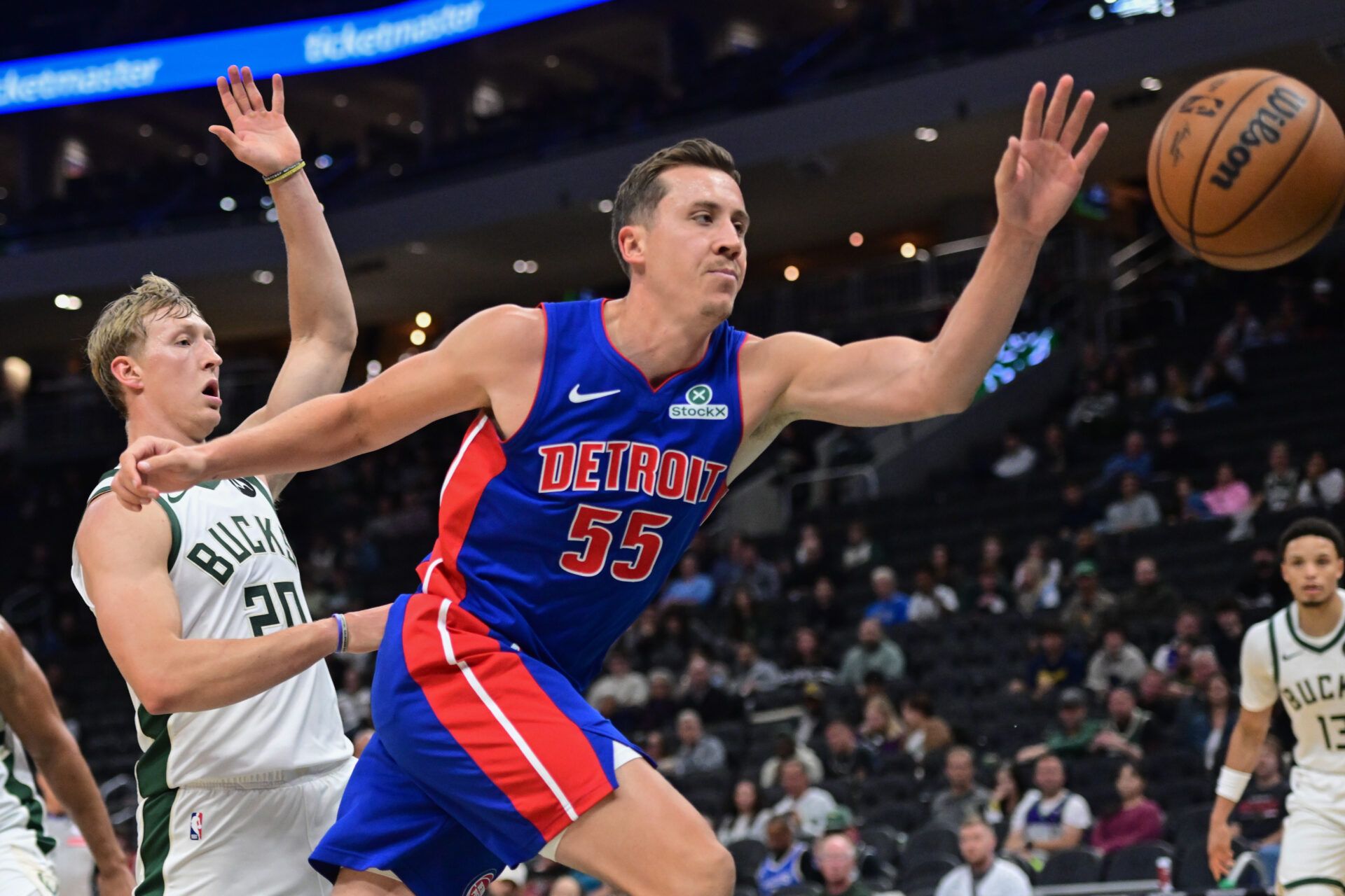 Detroit Pistons guard Duncan Robinson (55) and Milwaukee Bucks guard AJ Green (20) reach for a loose ball in the 3rd quarter at Fiserv Forum.