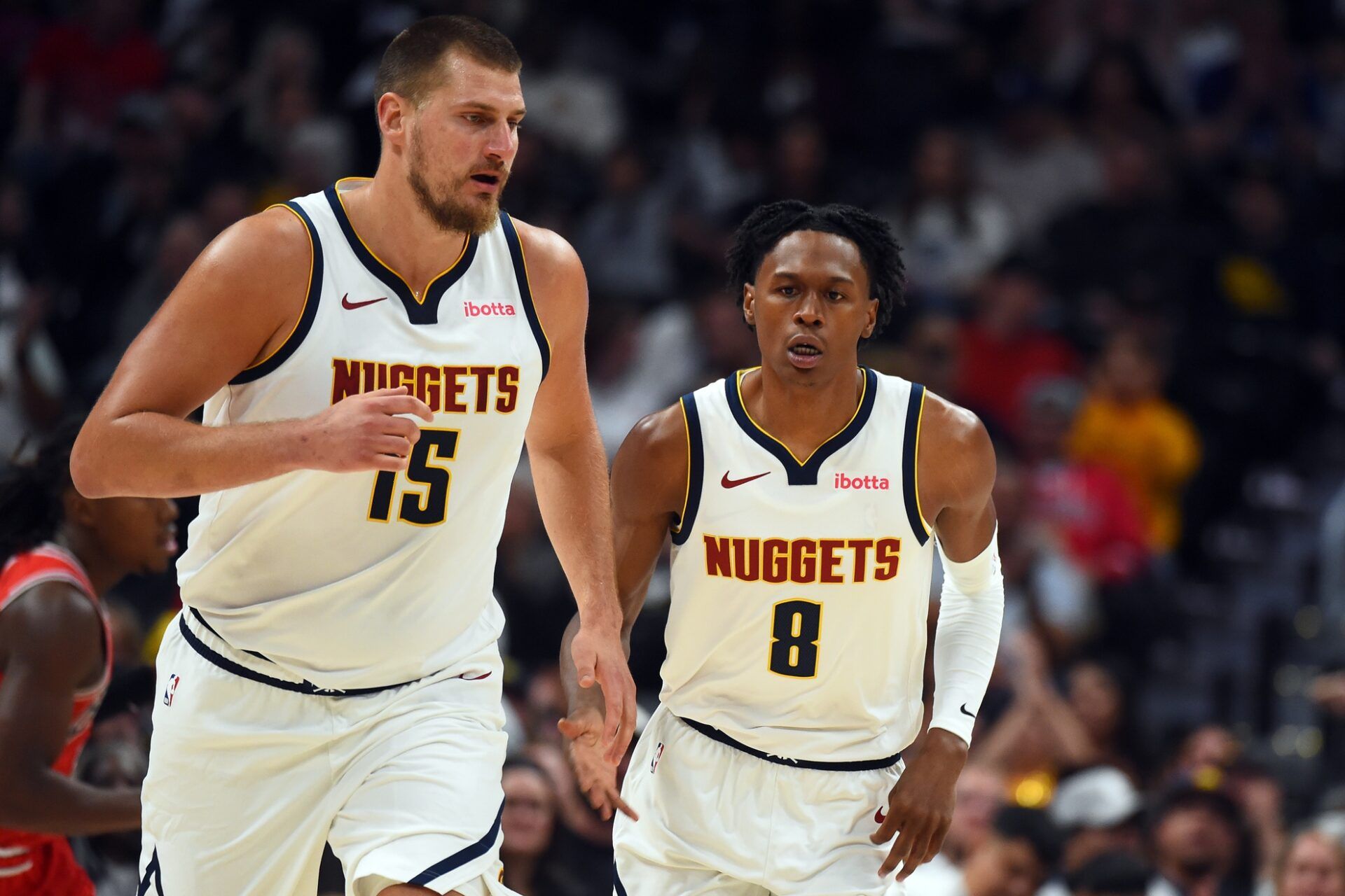 Denver Nuggets forward Peyton Watson (8) after scoring on an assist by  center Nikola Jokic (15) during the first half at Ball Arena.