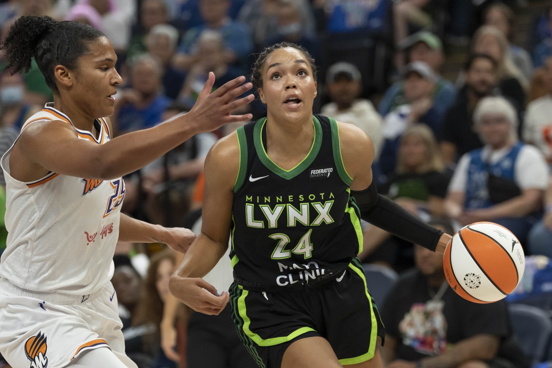 Minnesota Lynx forward Napheesa Collier (24) dribbles the ball past Phoenix Mercury forward Alyssa Thomas (25) in the first half during game one of the second round for the 2025 WNBA Playoffs at Target Center.