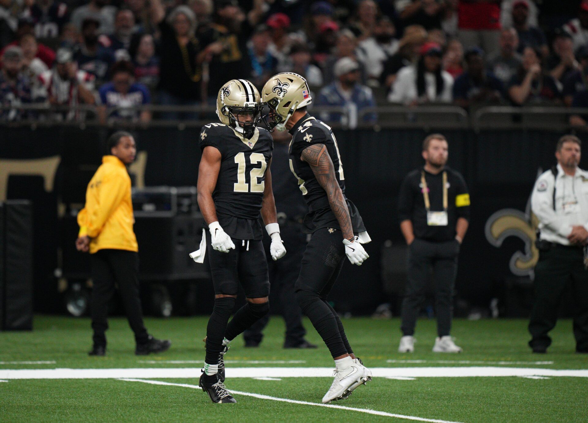 New Orleans Saints wide receiver Chris Olave (12) and wide receiver Devaughn Vele (14) react during the first quarter against the New England Patriots at Caesars Superdome.