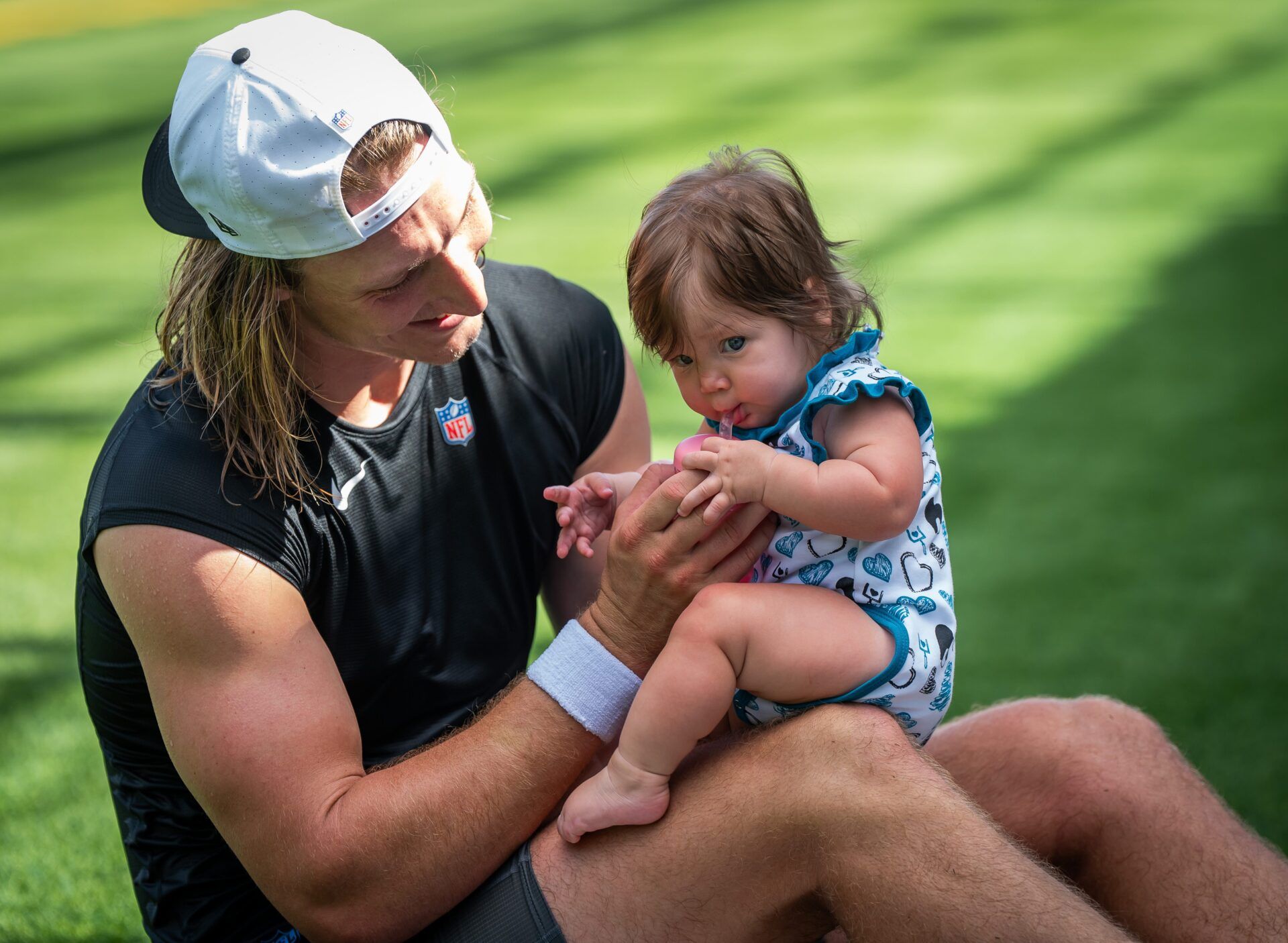 Jacksonville Jaguars quarterback Trevor Lawrence (16) gives his 6-month-old daughter Shae a sippy cup after a NFL training camp second session at the Miller Electric Center, Thursday, July 24, 2025, in Jacksonville, Fla. [Doug Engle/Florida Times-Union]