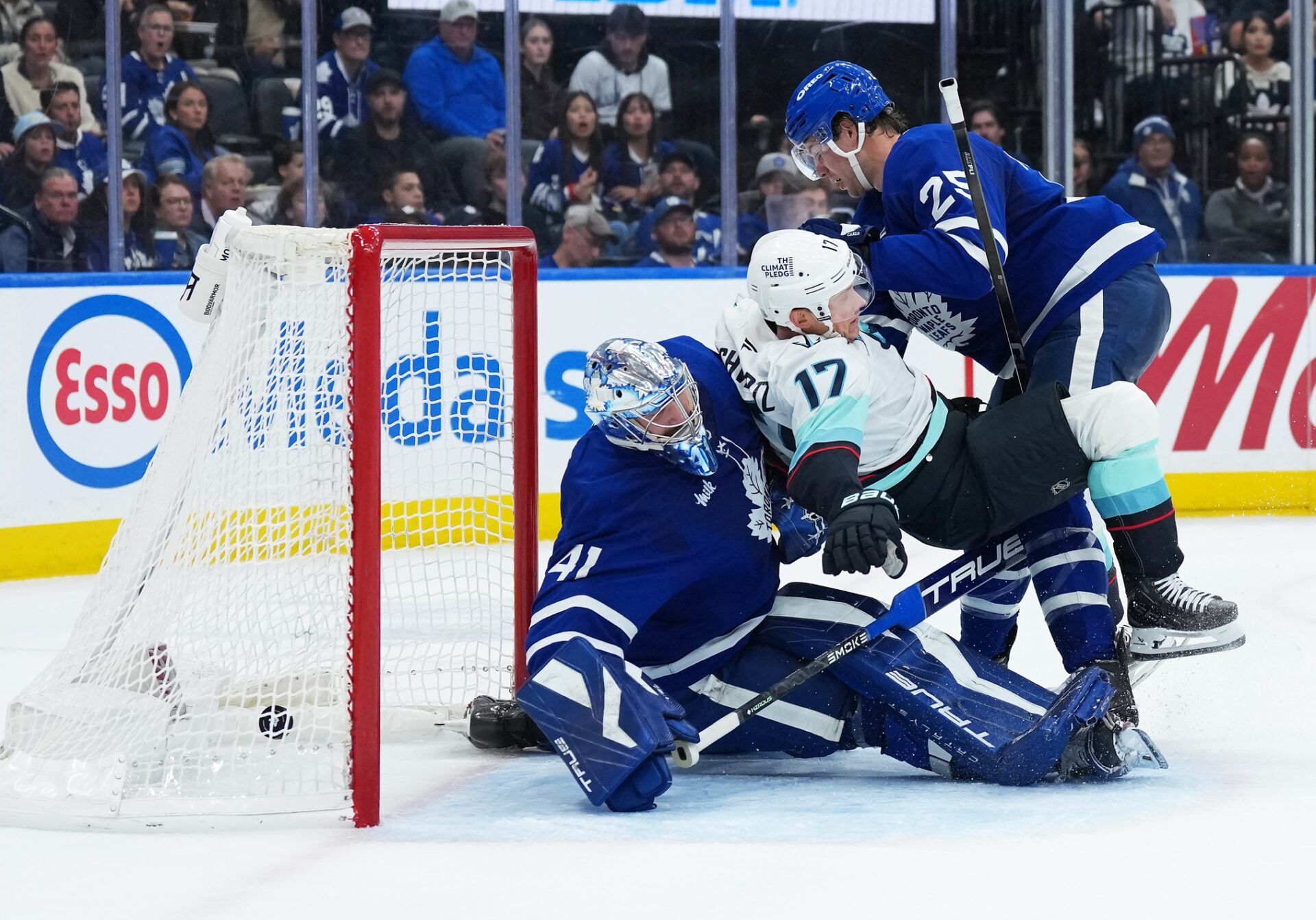 Toronto Maple Leafs defenseman Brandon Carlo (25) battles with Seattle Kraken left wing Jaden Schwartz (17) as the puck goes past  goaltender Anthony Stolarz (41) for a goal during the second period at Scotiabank Arena.