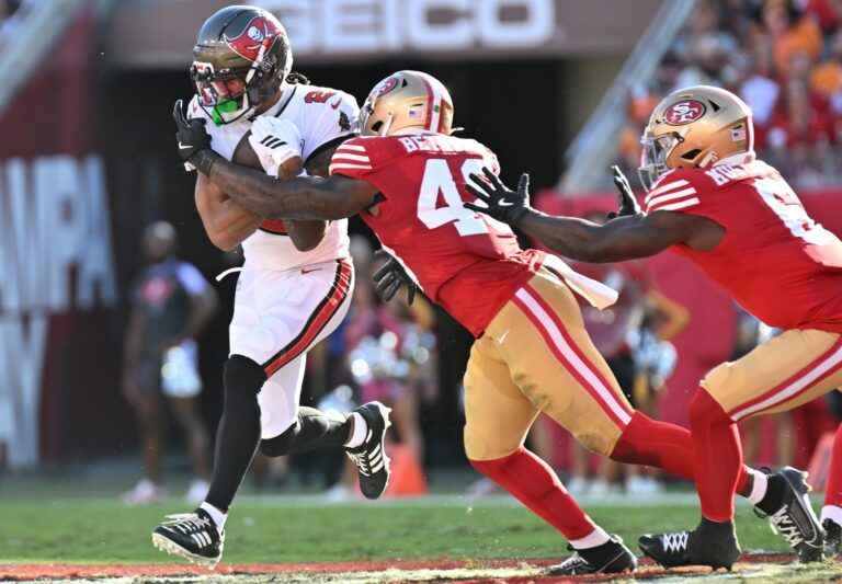 Oct 12, 2025; Tampa, Florida, USA: Tampa Bay Buccaneers wide receiver Emeka Egbuka (2) runs for a gain past San Francisco 49ers linebacker Tatum Bethune (48) during the second quarter at Raymond James Stadium.