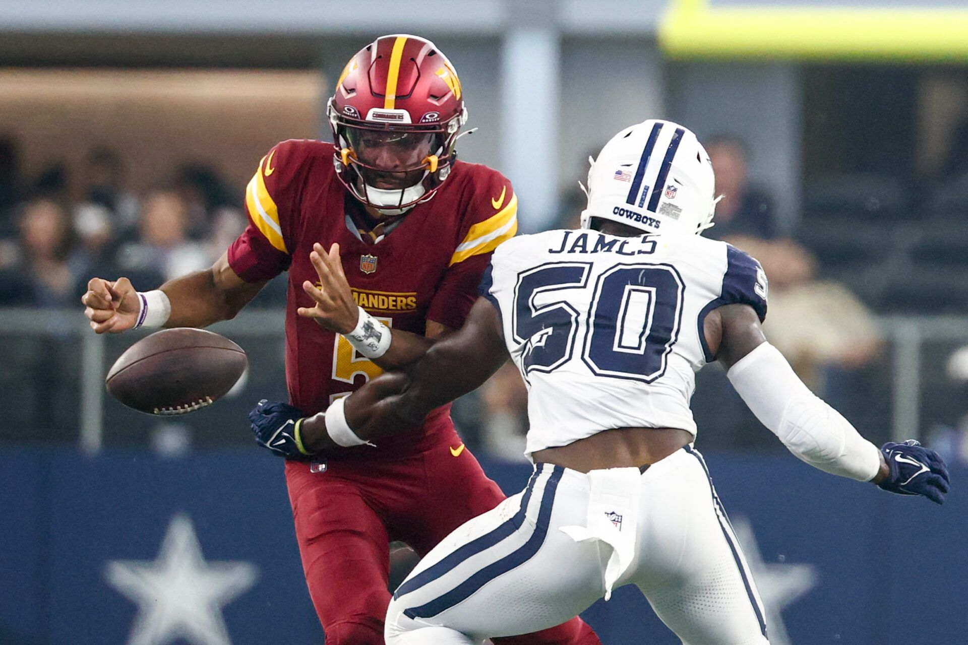 Washington Commanders quarterback Jayden Daniels (5) fumbles the ball defended by Dallas Cowboys linebacker Shemar James (50) during the third quarter of the game at AT&T Stadium.