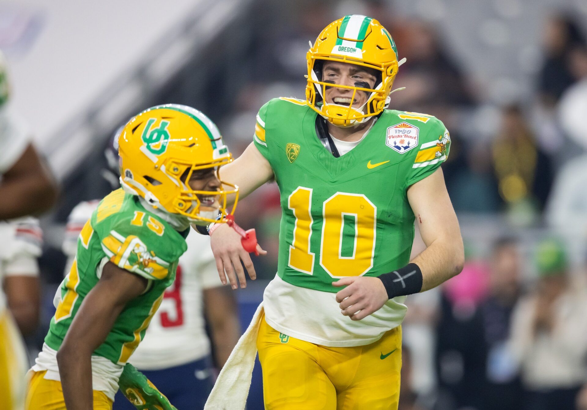 Oregon Ducks quarterback Bo Nix (10) celebrates a touchdown with wide receiver Tez Johnson (15) during the second half against the Liberty Flames in the 2024 Fiesta Bowl at State Farm Stadium.