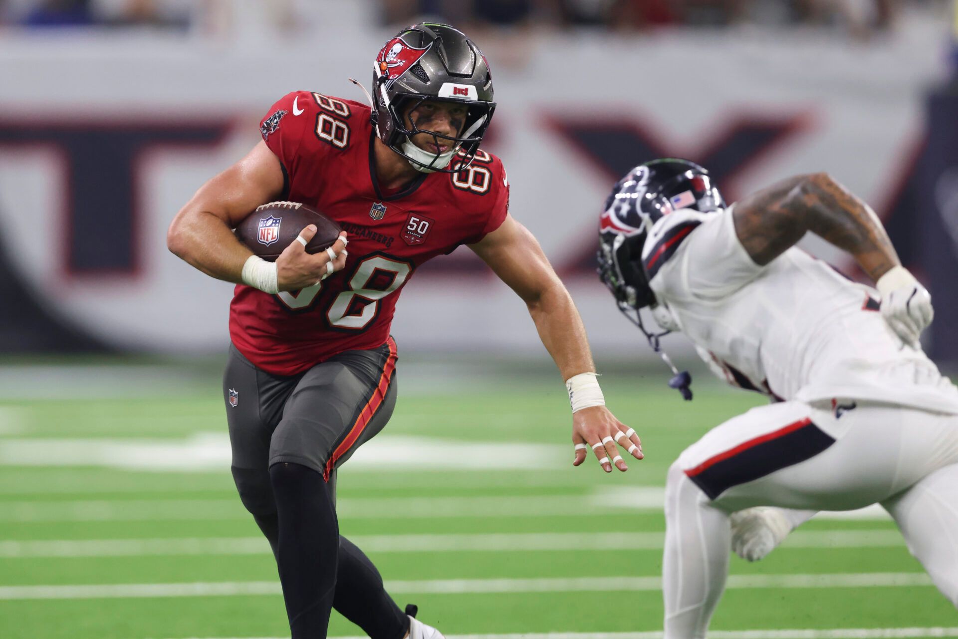 Tampa Bay Buccaneers tight end Cade Otton (88) runs with the ball after a recpetion as Houston Texans safety Jalen Pitre (5) attempts to make a tackle during the fourth quarter at NRG Stadium.