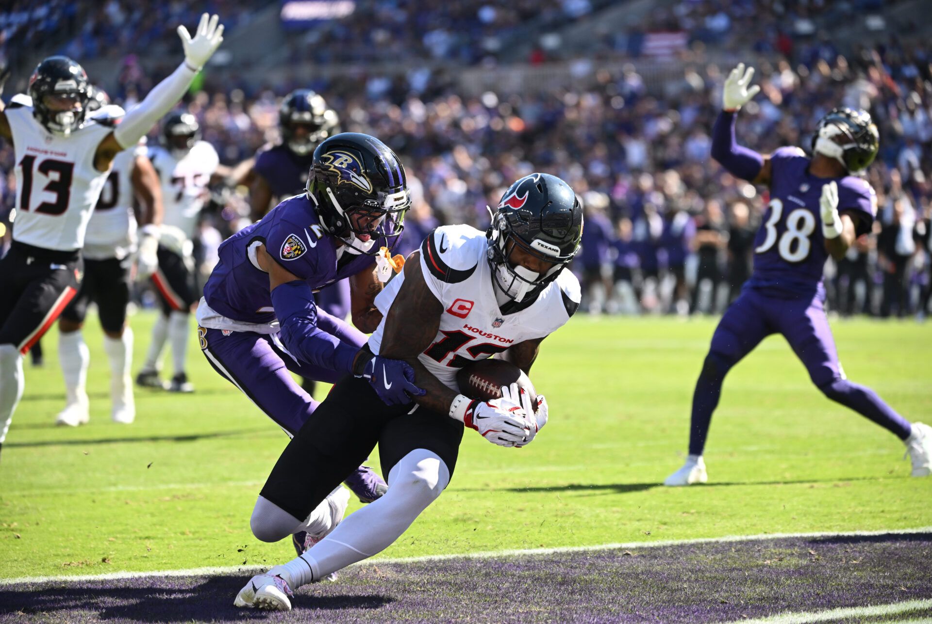 Houston Texans wide receiver Nico Collins (12) runs for a touchdown past Baltimore Ravens cornerback Nate Wiggins (2) during the second quarter at M&T Bank Stadium.