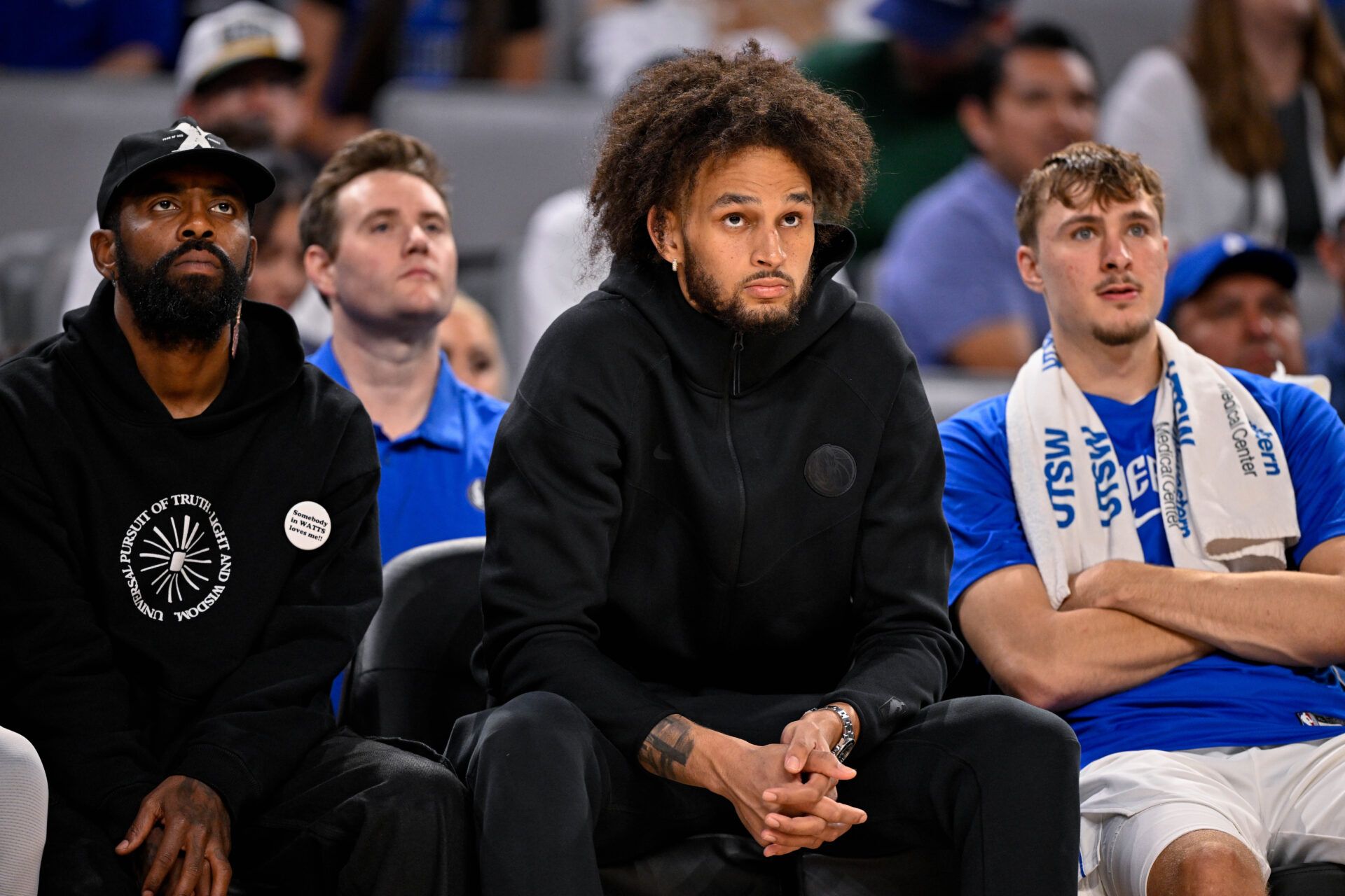 Dallas Mavericks guard Kyrie Irving (left) and center Dereck Lively II (center) and forward Cooper Flagg (right) look on during the game between the Dallas Mavericks and the Oklahoma City Thunder at Dickie's Arena.