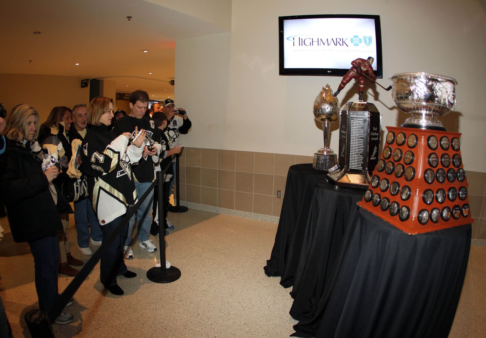 Fans admire the 2011-12 NHL trophies won by Pittsburgh Penguins center Evgeni Malkin (not pictured) including the Hart Memorial Trophy (far left) and the Ted Lindsay Award (center) and the Art Ross trophy (near right) before the game against the Toronto Maple Leafs at the CONSOL Energy Center.