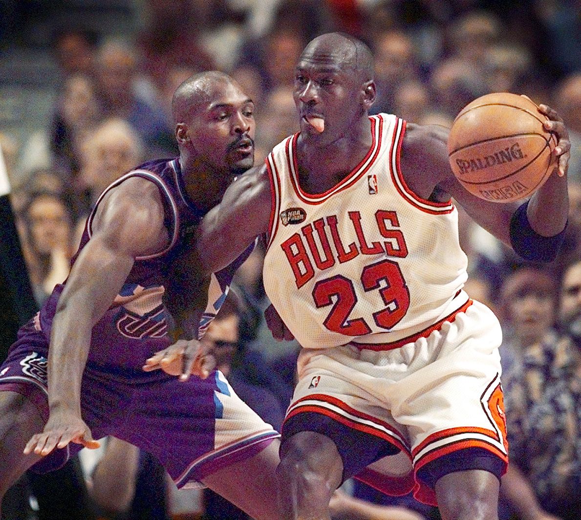 Chicago Bulls guard Michael Jordan (23), right, goes up against Utah Jazz player Bryon Russell (3) in Game 5 of the 1998 NBA Finals.