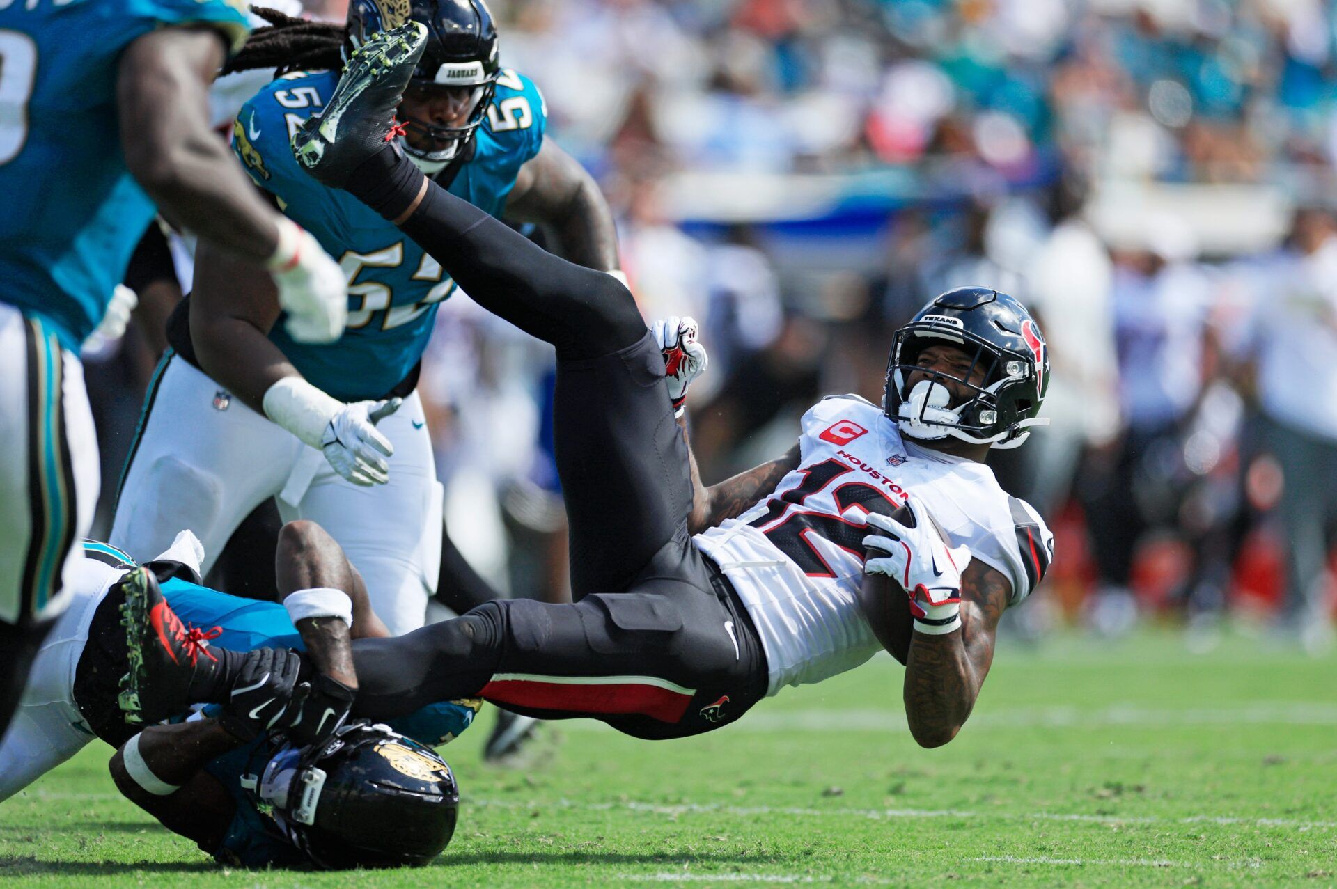 Jacksonville Jaguars cornerback Jourdan Lewis (2) tackles Houston Texans wide receiver Nico Collins (12) during the fourth quarter of an NFL football matchup at EverBank Stadium, Sunday, Sept. 21, 2025, in Jacksonville, Fla. The Jaguars defeated the Texans 17-10.