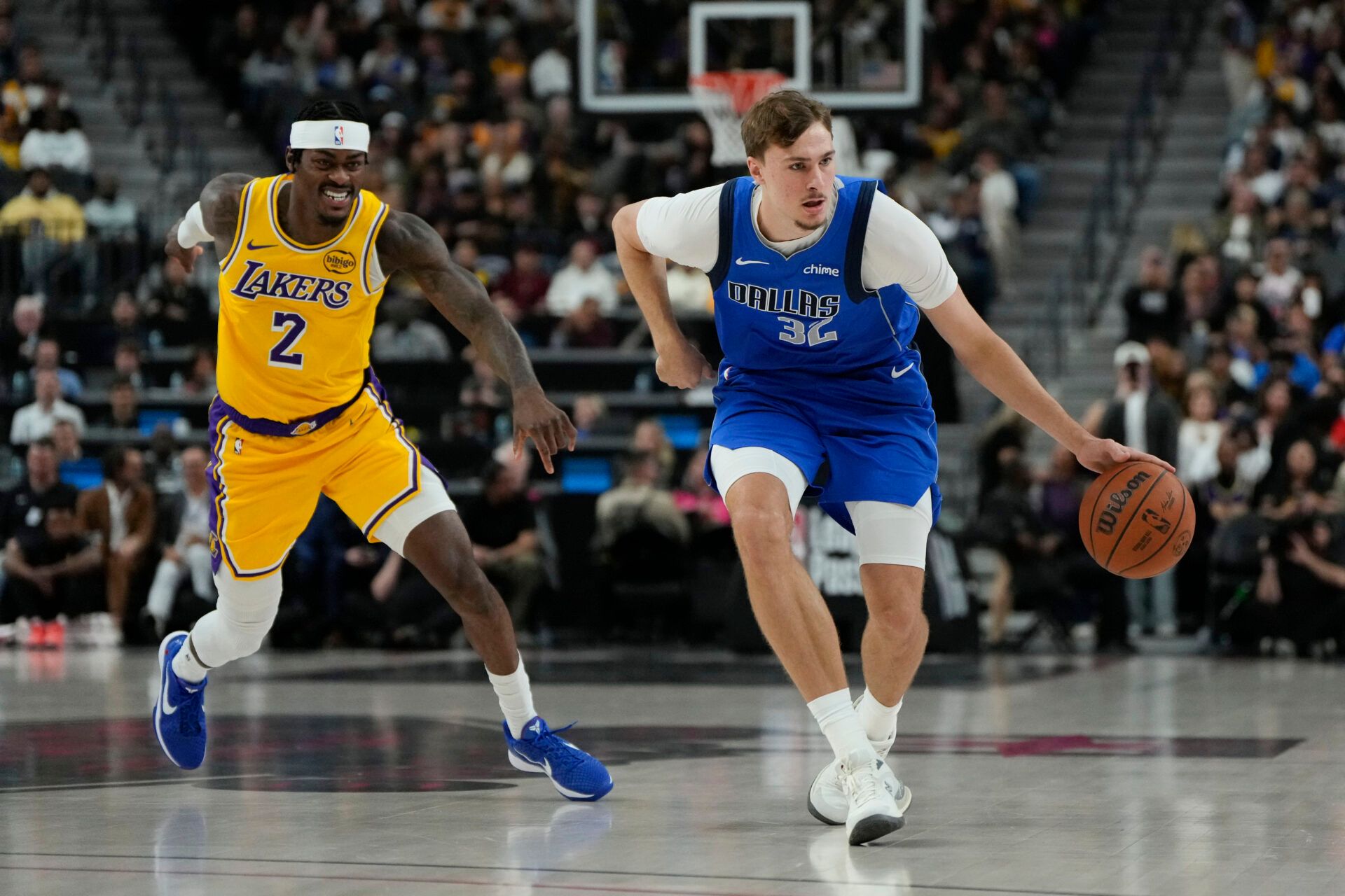 Dallas Mavericks forward Cooper Flagg (32) dribbles the ball past Los Angeles Lakers forward Jarred Vanderbilt (2) during the first half at T-Mobile Arena.