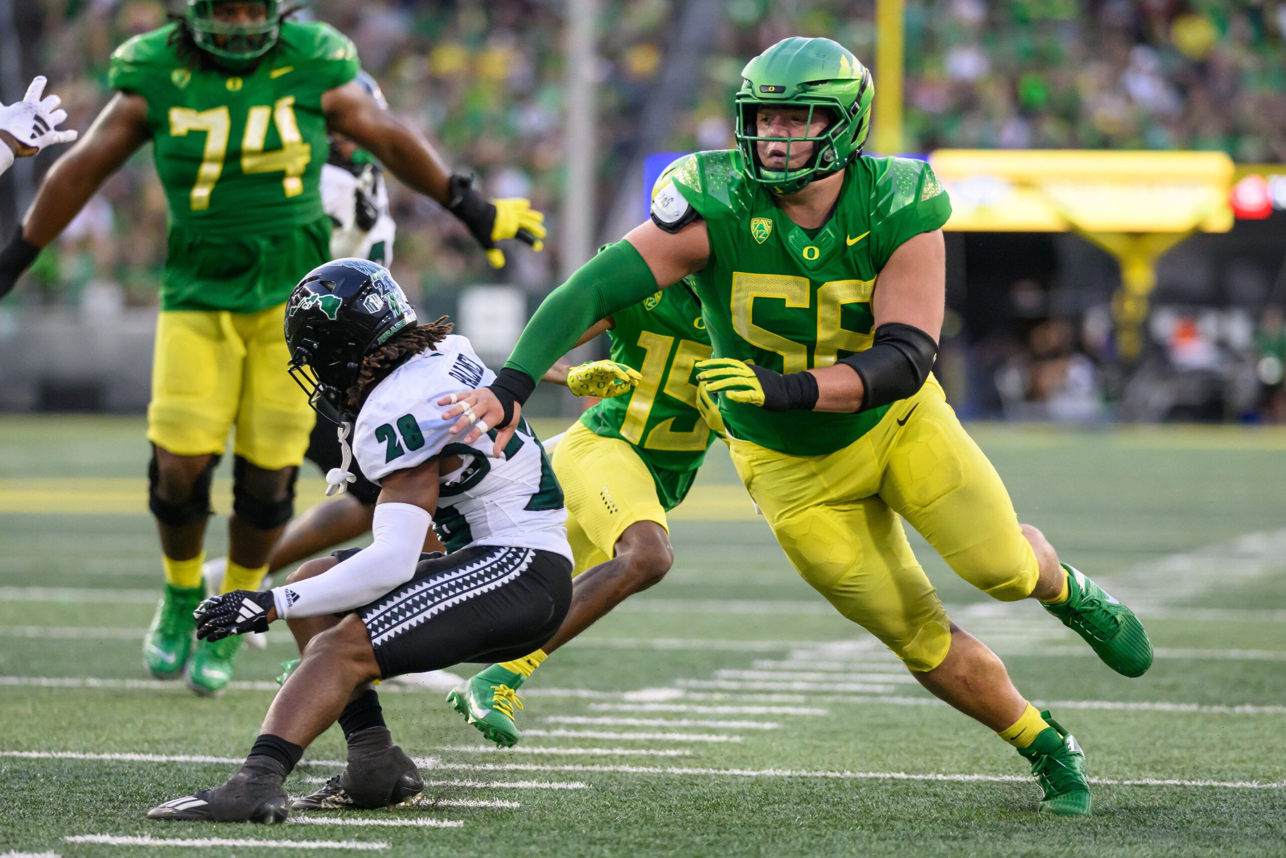 Oregon Ducks defensive lineman A'Mauri Washington (58) on pass rush against Hawaii Warriors defensive back Elijah Palmer (28) during the third quarter at Autzen Stadium.