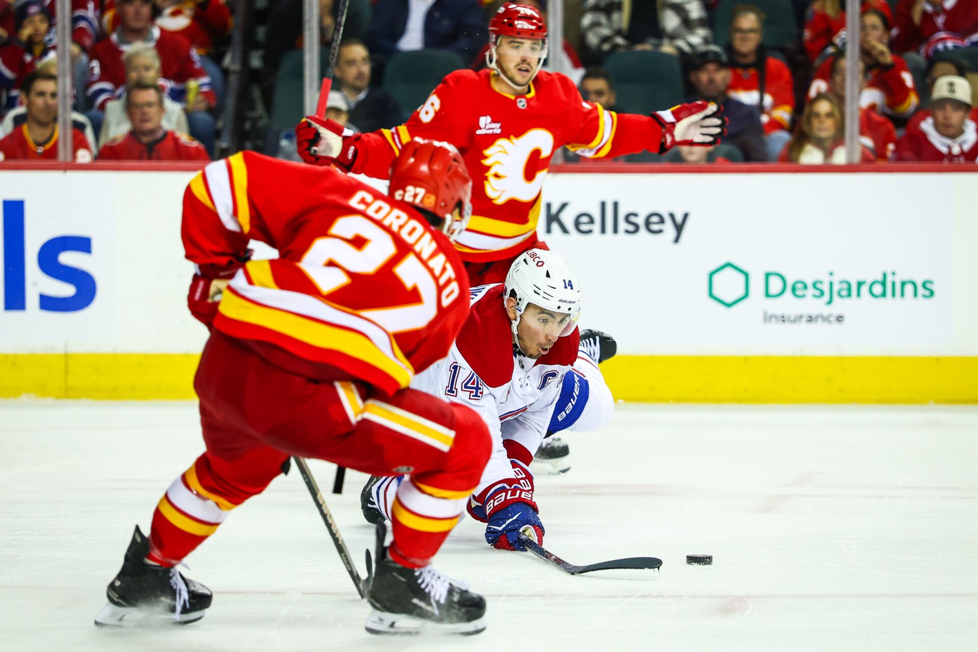 Montreal Canadiens center Nick Suzuki (14) battles for the puck against the Calgary Flames during the third period at Scotiabank Saddledome.