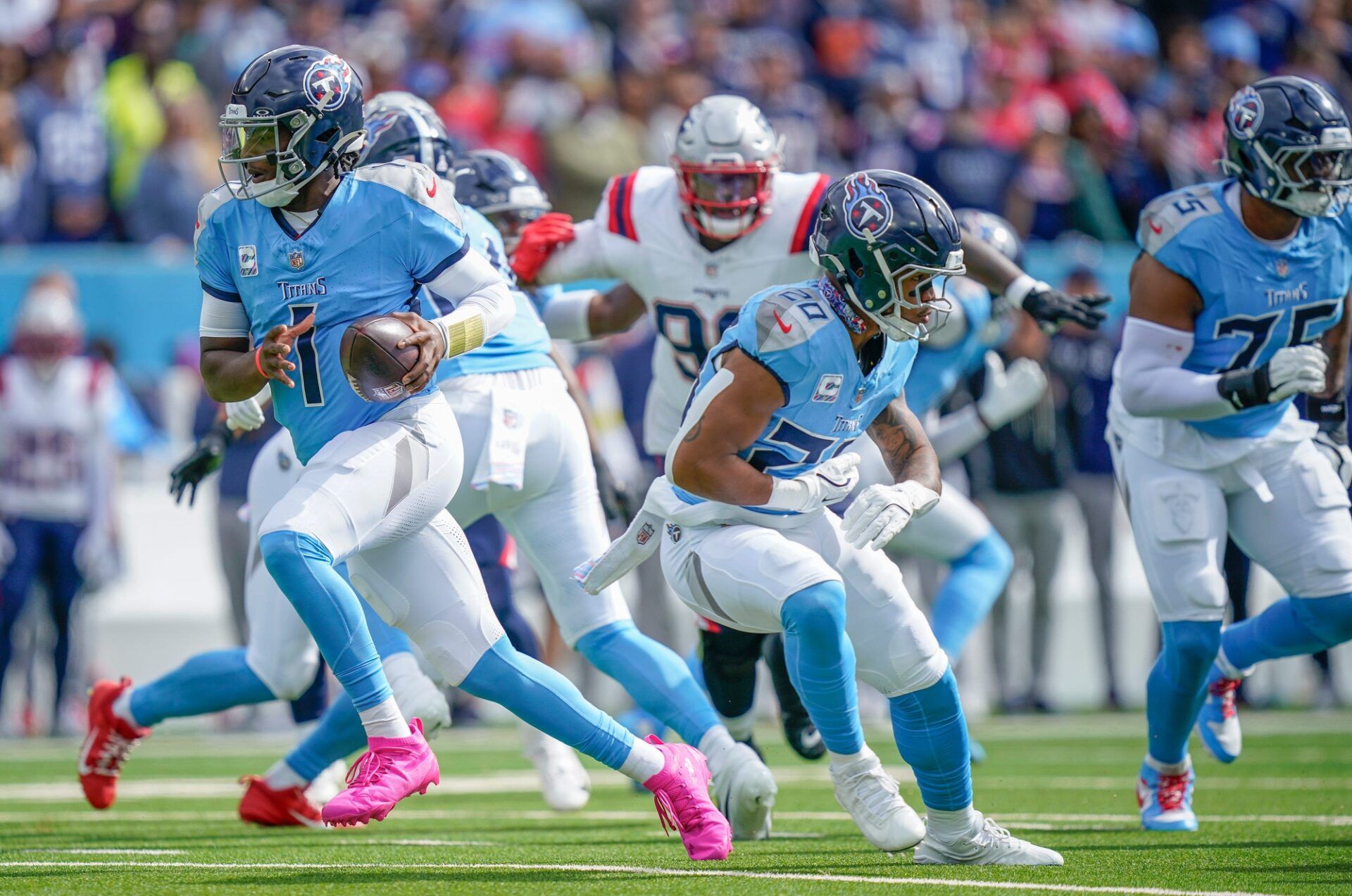 Tennessee Titans rolls out after faking a handoff to running back Tony Pollard (20) during the first quarter at Nissan Stadium in Nashville, Tenn., Sunday, Oct. 19, 2025.