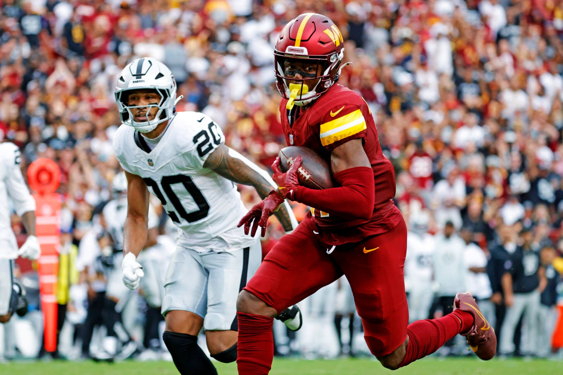 Washington Commanders wide receiver Terry McLaurin (17) runs the ball during the second half as Las Vegas Raiders safety Isaiah Pola-Mao (20) defends at Northwest Stadium.