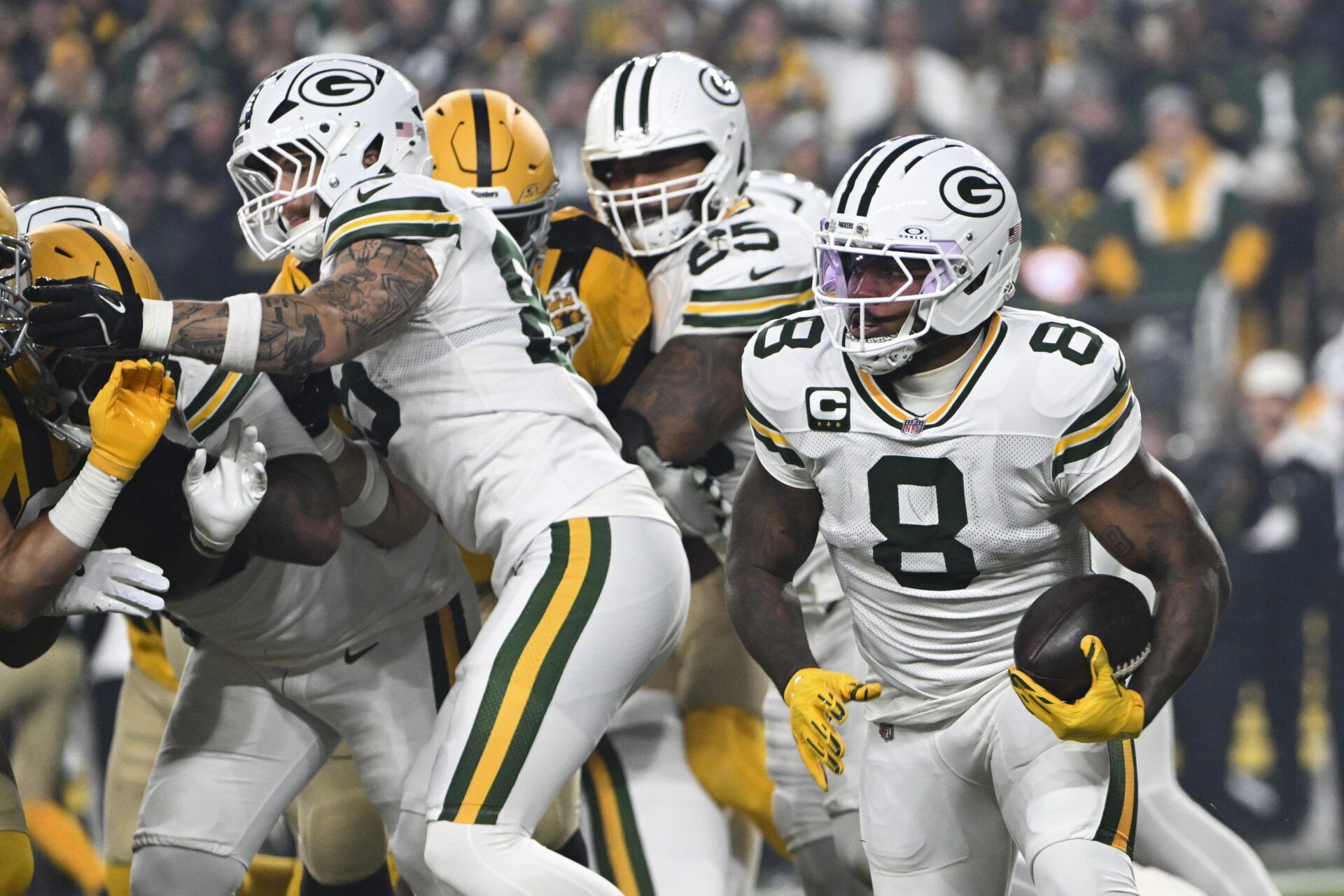 Green Bay Packers running back Josh Jacobs (8) runs the ball against the Pittsburgh Steelers during the first quarter at Acrisure Stadium.