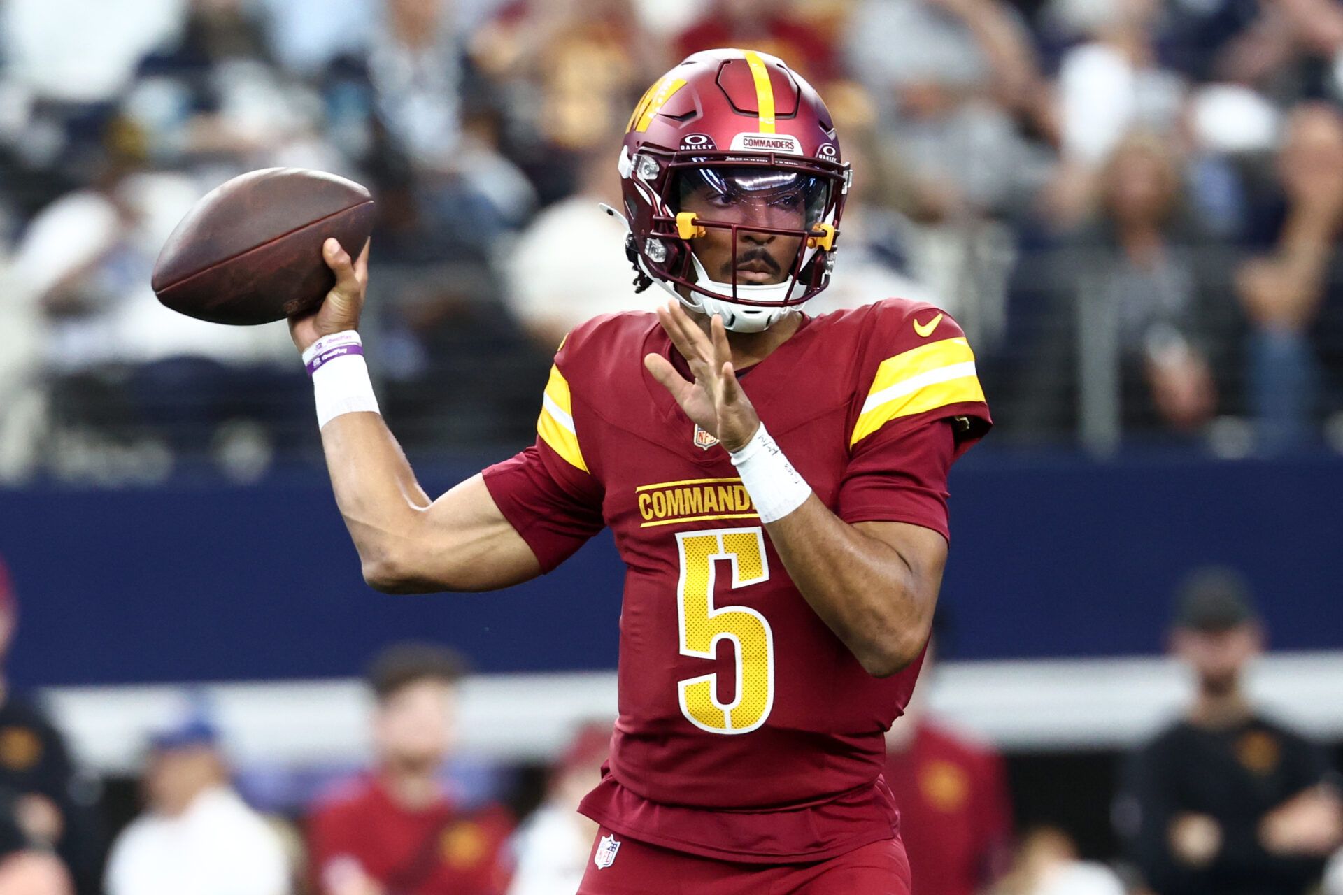Washington Commanders quarterback Jayden Daniels (5) passes the ball against the Dallas Cowboys during the first quarter of the game at AT&T Stadium.