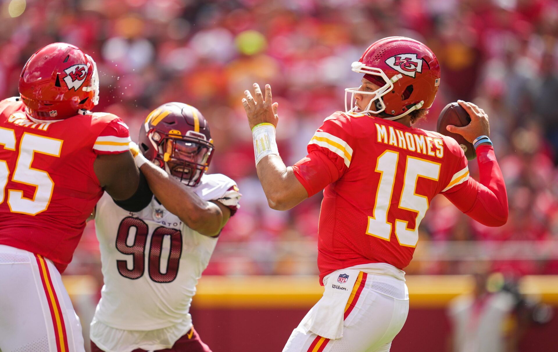 Kansas City Chiefs quarterback Patrick Mahomes (15) throws a pass as Washington Commanders defensive end Montez Sweat (90) defends during the first half at GEHA Field at Arrowhead Stadium.