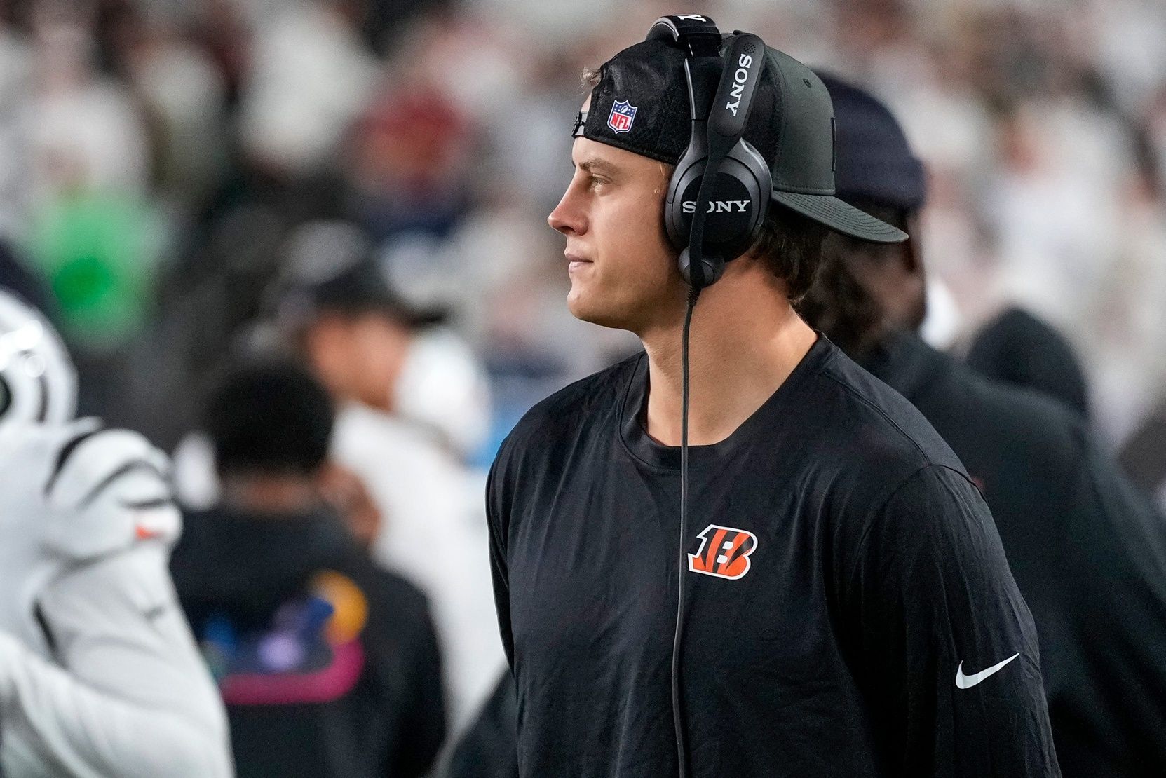 Injured Cincinnati Bengals quarterback Joe Burrow (9) walks the sideline with a headset in the second quarter of the NFL Week 7 game between the Cincinnati Bengals and the Pittsburgh Steelers at Paycor Stadium in downtown Cincinnati on Thursday, Oct. 16, 2025.