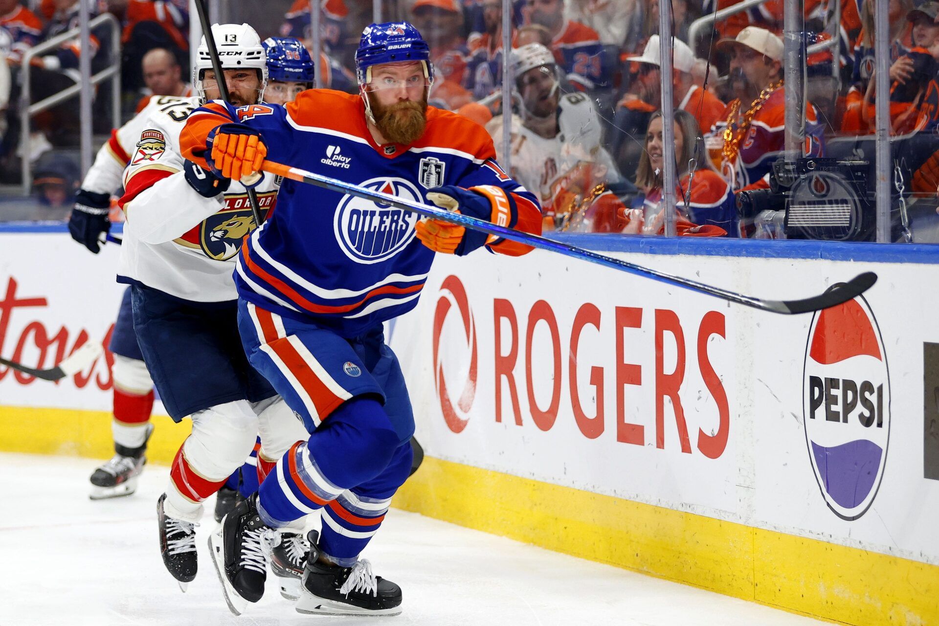 Edmonton Oilers defenseman Mattias Ekholm (14) and Florida Panthers center Sam Reinhart (13) skate for a puck during the second period in game two of the 2025 Stanley Cup Final at Rogers Place.