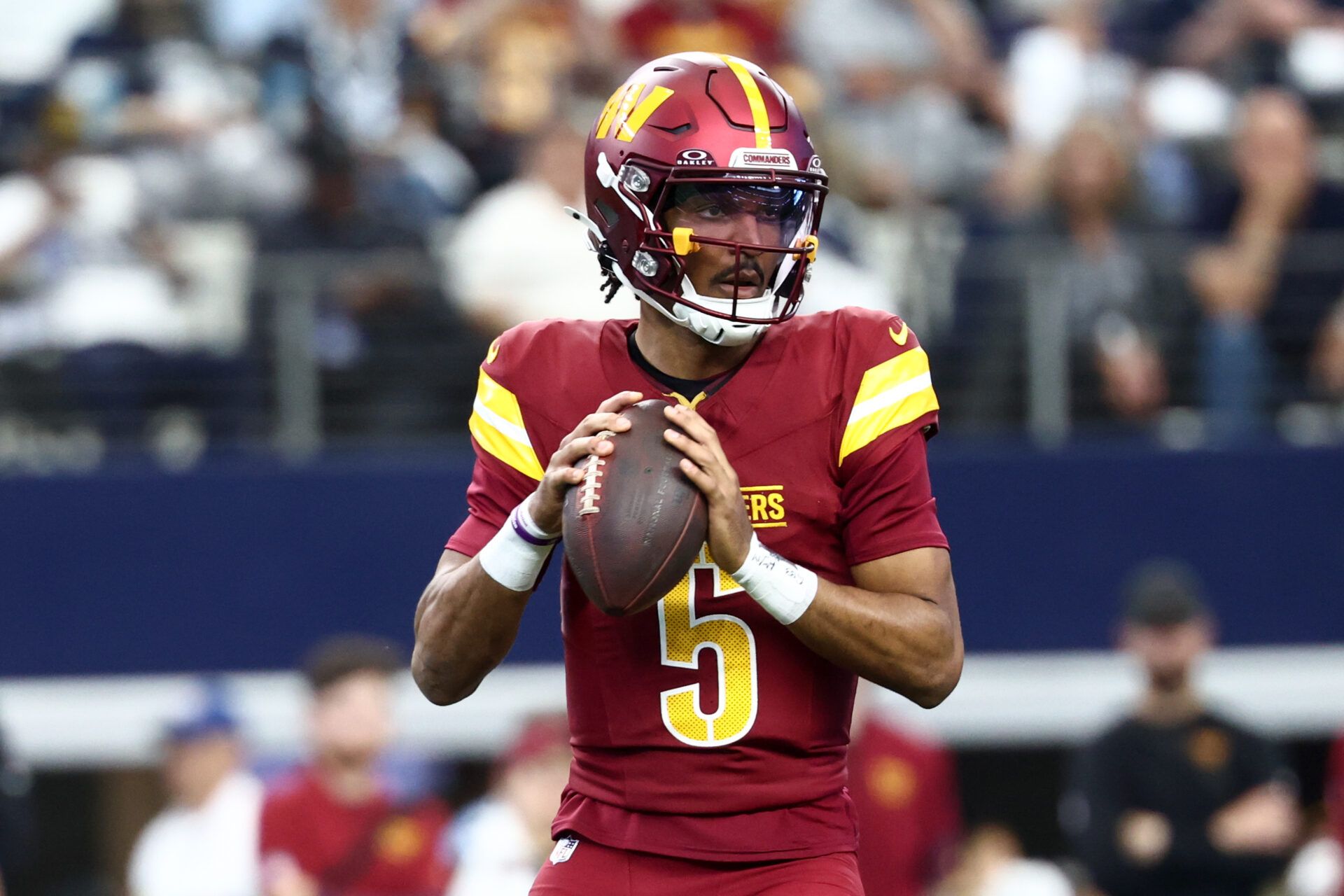 Washington Commanders quarterback Jayden Daniels (5) looks to pass the ball against the Dallas Cowboys during the first quarter of the game at AT&T Stadium.