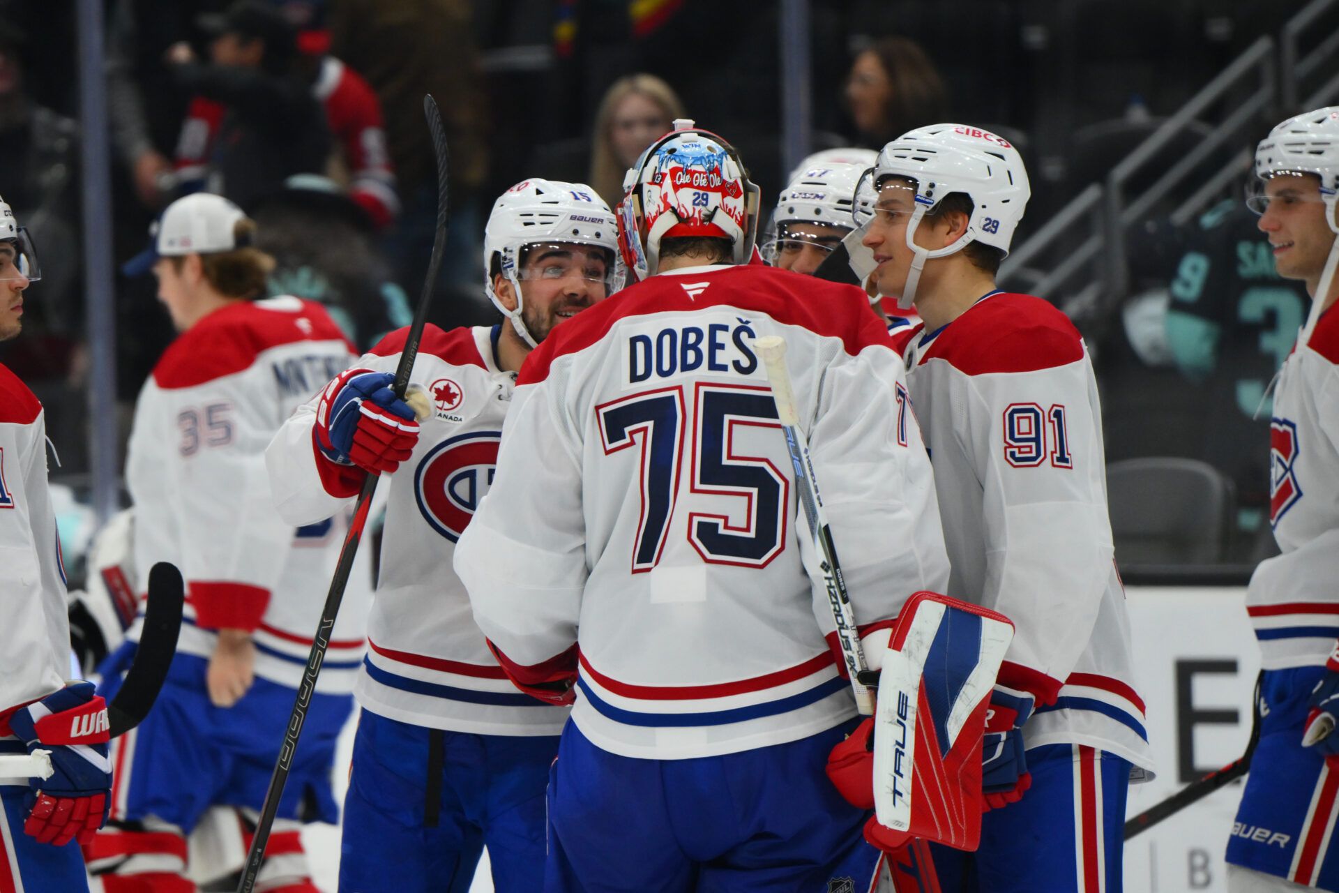 Montreal Canadiens center Alex Newhook (15) and Montreal Canadiens goaltender Jakub Dobes (75) celebrate defeating the Seattle Kraken during overtime at Climate Pledge Arena.