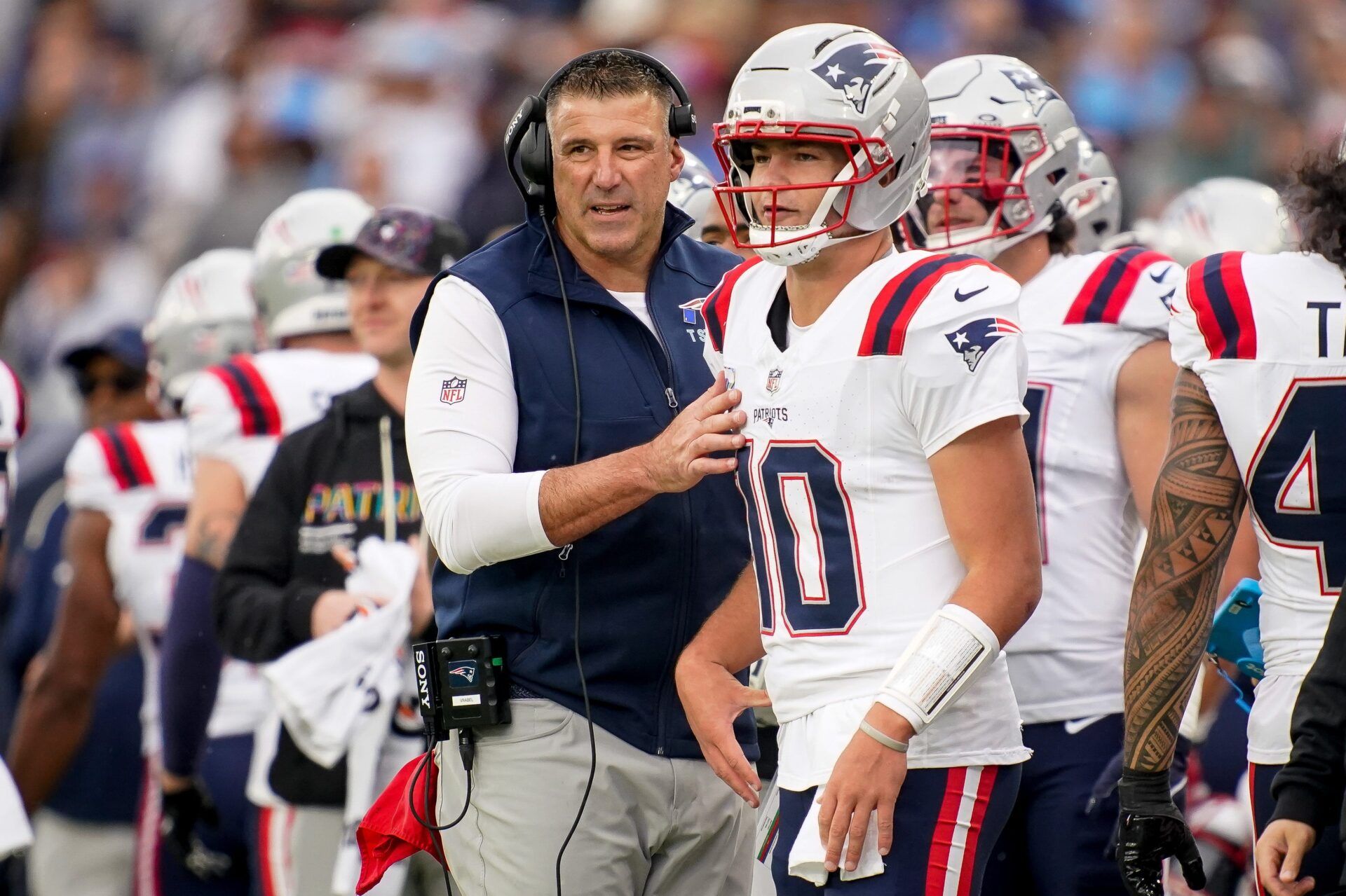 New England Patriots coach Mike Vrabel talks to quarterback Drake Maye (10) during the second quarter at Nissan Stadium in Nashville, Tenn., Sunday, Oct. 19, 2025.
