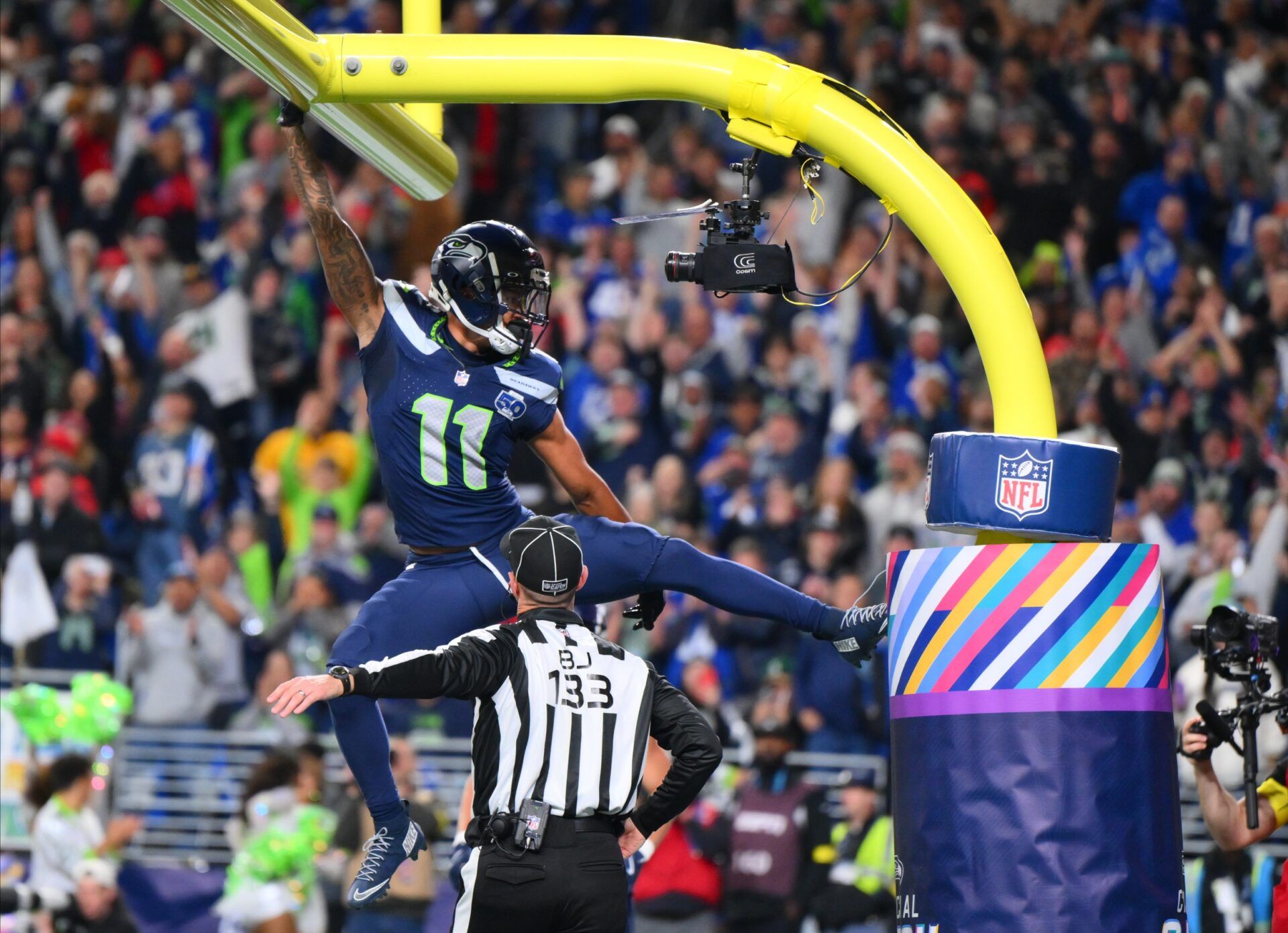 Seattle Seahawks wide receiver Jaxon Smith-Njigba (11) celebrates on the goal post after a touchdown during the first quarter against the Houston Texans at Lumen Field.