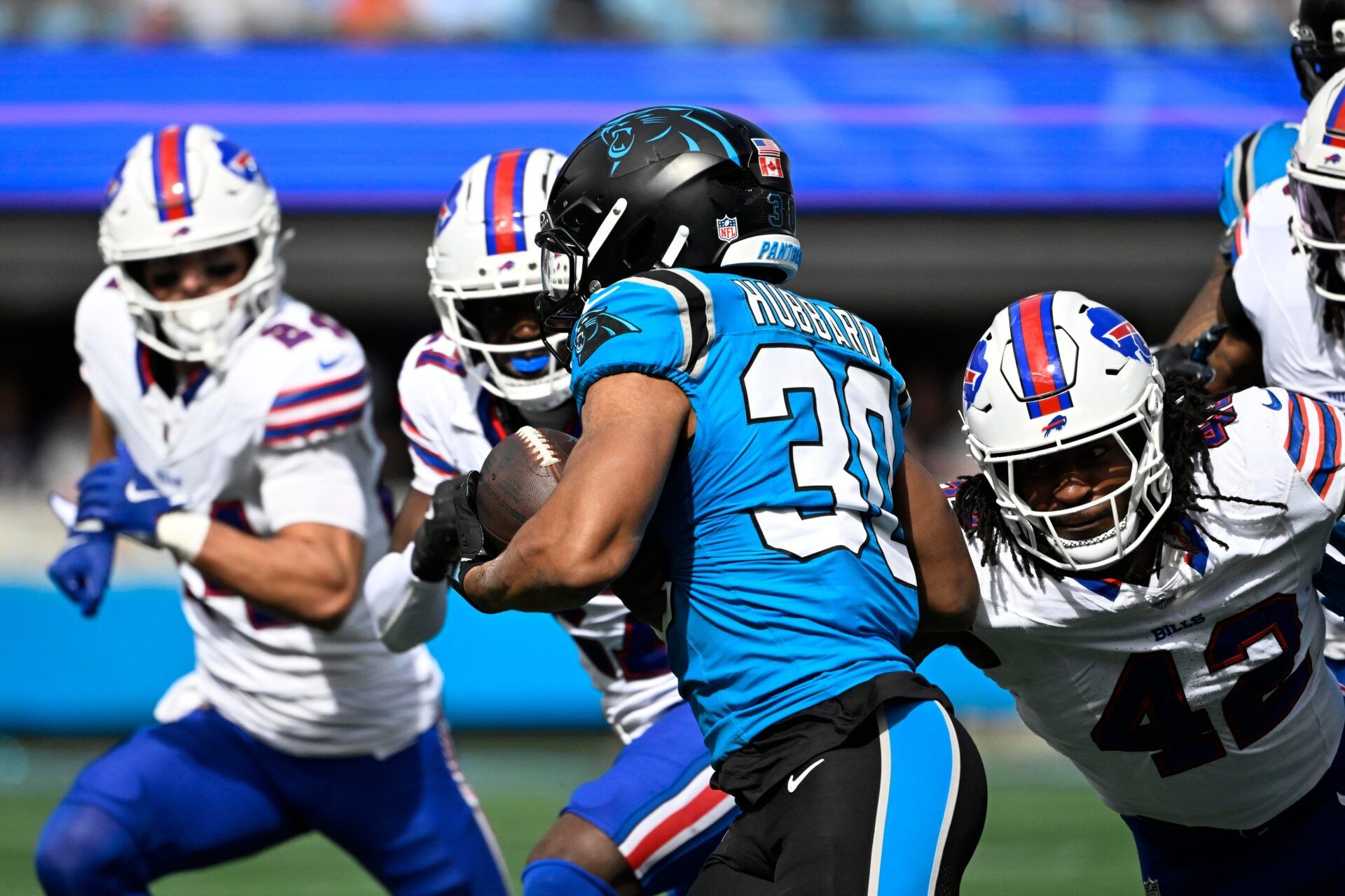 Carolina Panthers running back Chuba Hubbard (30) with the ball as Buffalo Bills linebacker Dorian Williams (42) defends in the first quarter at Bank of America Stadium.