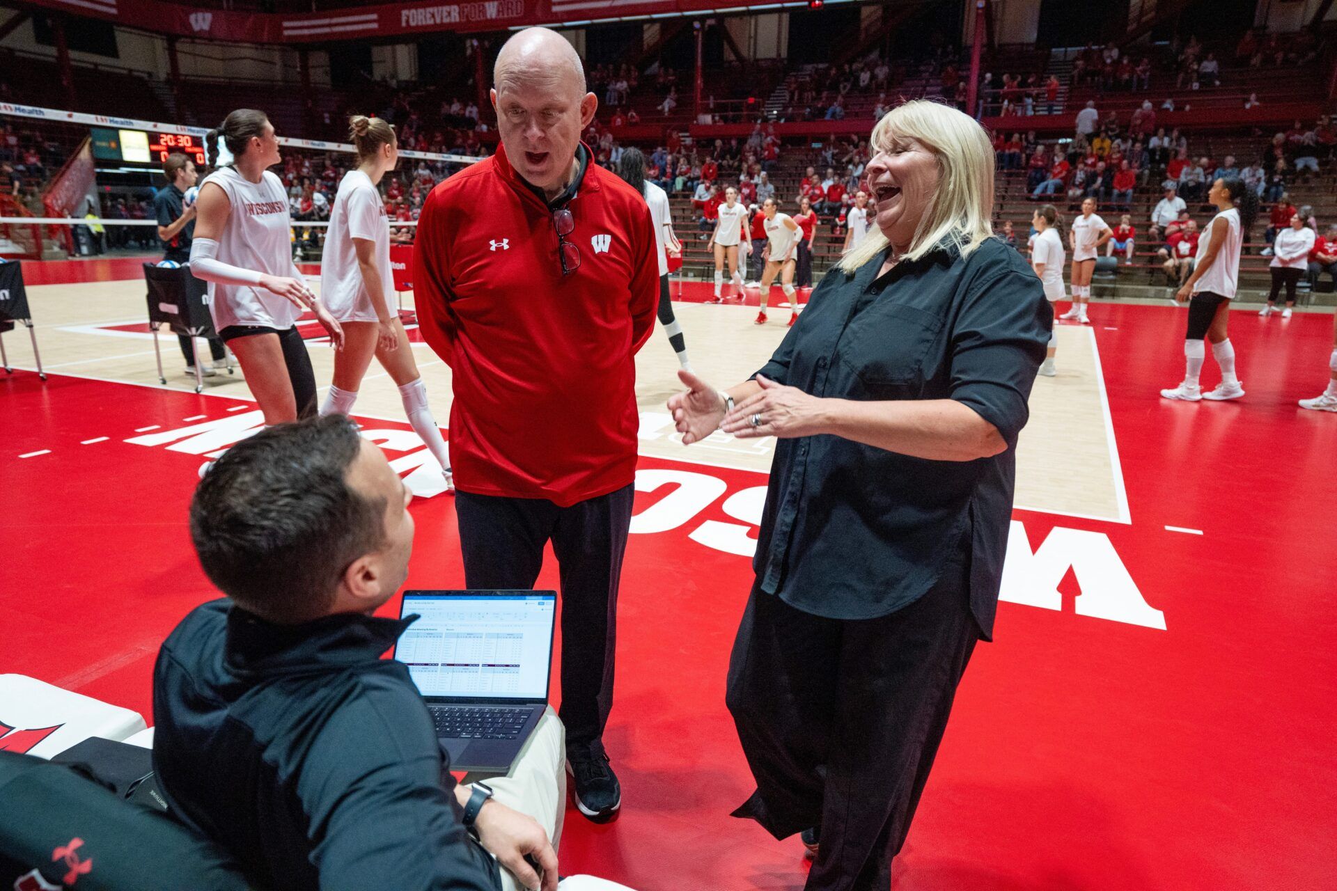 Wisconsin head coach Kelly Sheffield, center and UW-Milwaukee head coach Susie Johnson talk with Wisconsin director of player personnel and analytics Gary White before their volleyball match Tuesday, September 9, 2025, at the Wisconsin Field House in Madison, Wisconsin.