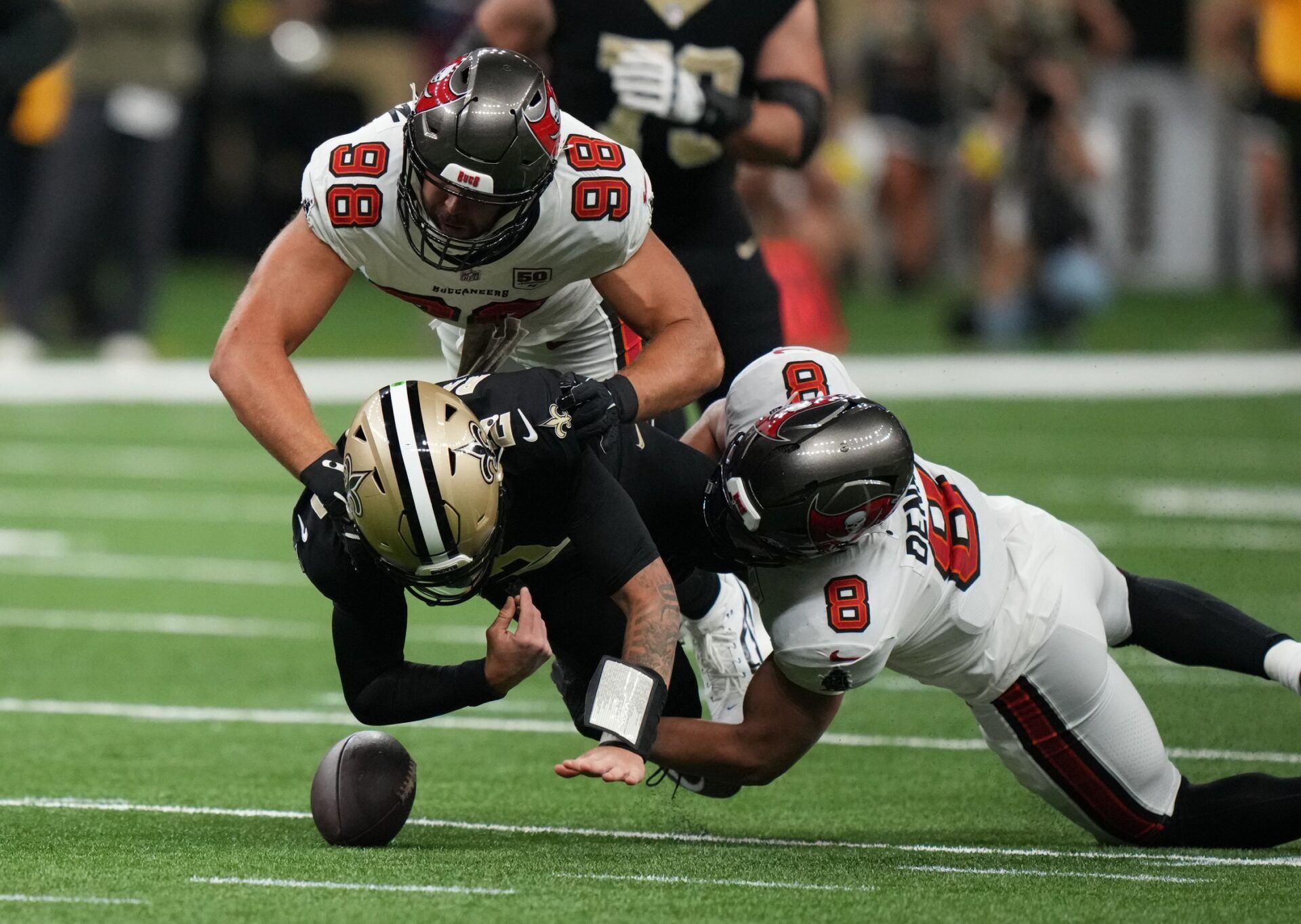 New Orleans Saints quarterback Spencer Rattler (2) loses the football during a tackle by Tampa Bay Buccaneers quarterback Connor Bazelak (8) and linebacker Anthony Nelson (98) during the first quarter at Caesars Superdome.