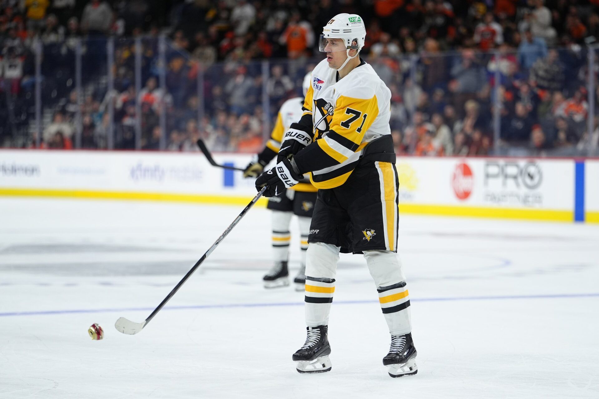 Pittsburgh Penguins center Evgeni Malkin (71) removes a beer can from the ice against the Philadelphia Flyers in overtime at Xfinity Mobile Arena.