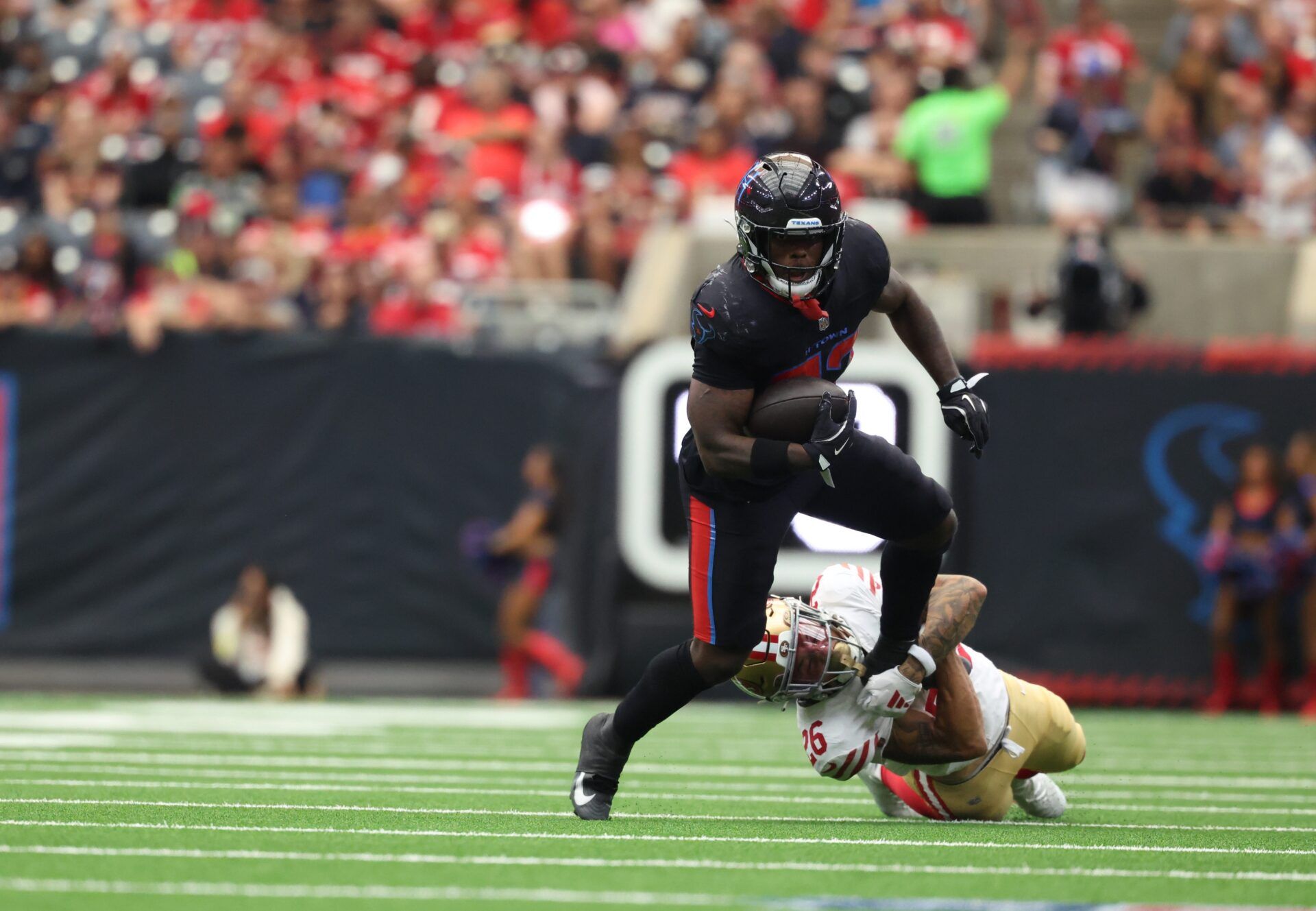 Houston Texans running back Woody Marks (27) runs for a gain past a tackle by San Francisco 49ers cornerback Deommodore Lenoir (2) during the second quarter at NRG Stadium.