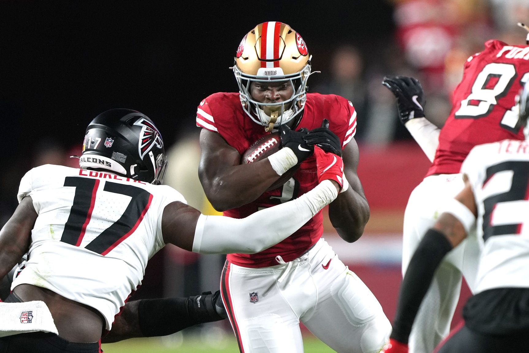 San Francisco 49ers running back Brian Robinson Jr. (center) carries the ball against Atlanta Falcons linebacker Arnold Ebiketie (17) during the fourth quarter at Levi's Stadium.