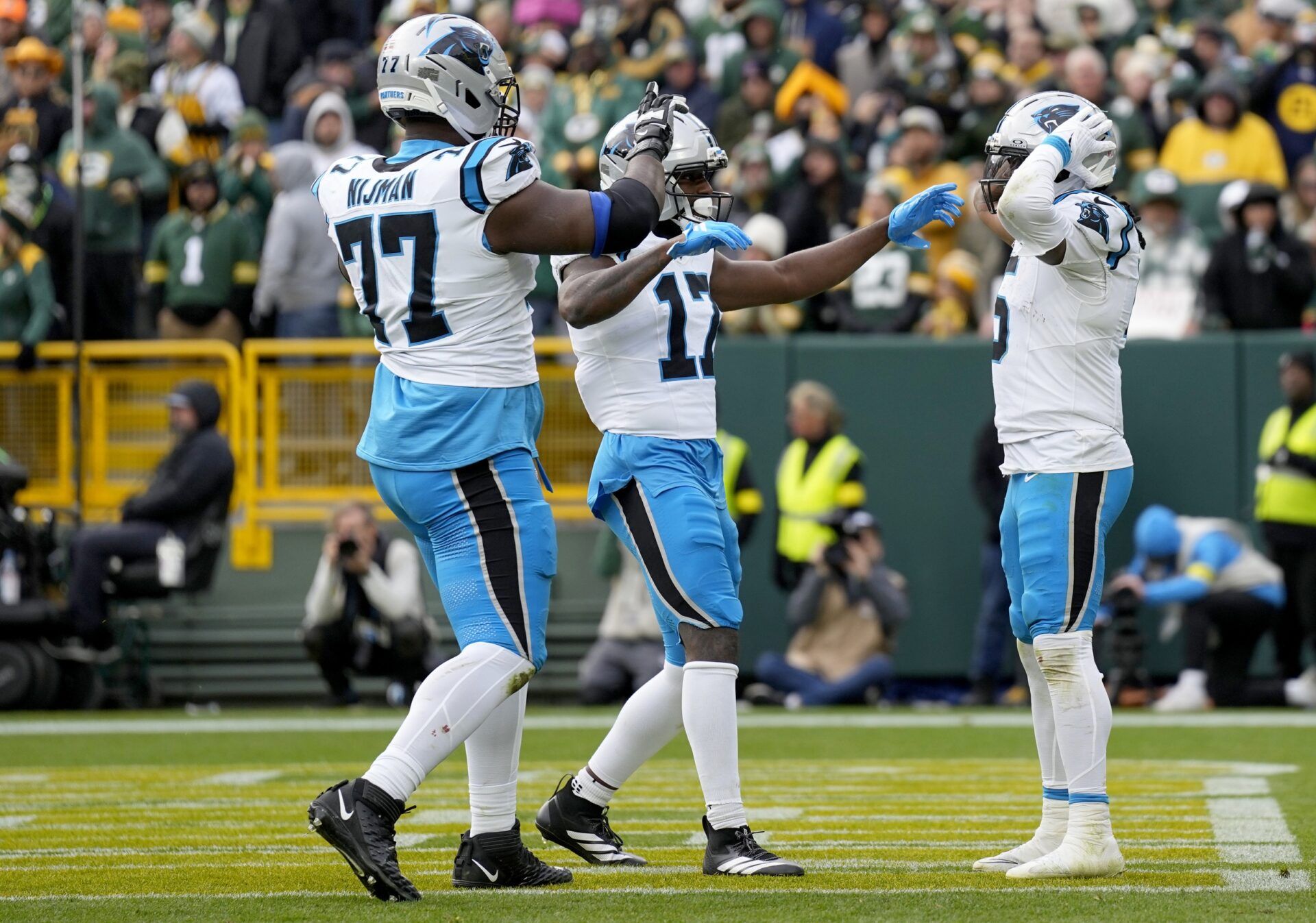 Carolina Panthers running back Rico Dowdle (5) celebrates with offensive tackle Yosh Nijman (77) and wide receiver Xavier Legette (17) after a touchdown during the second half against the Green Bay Packers at Lambeau Field.