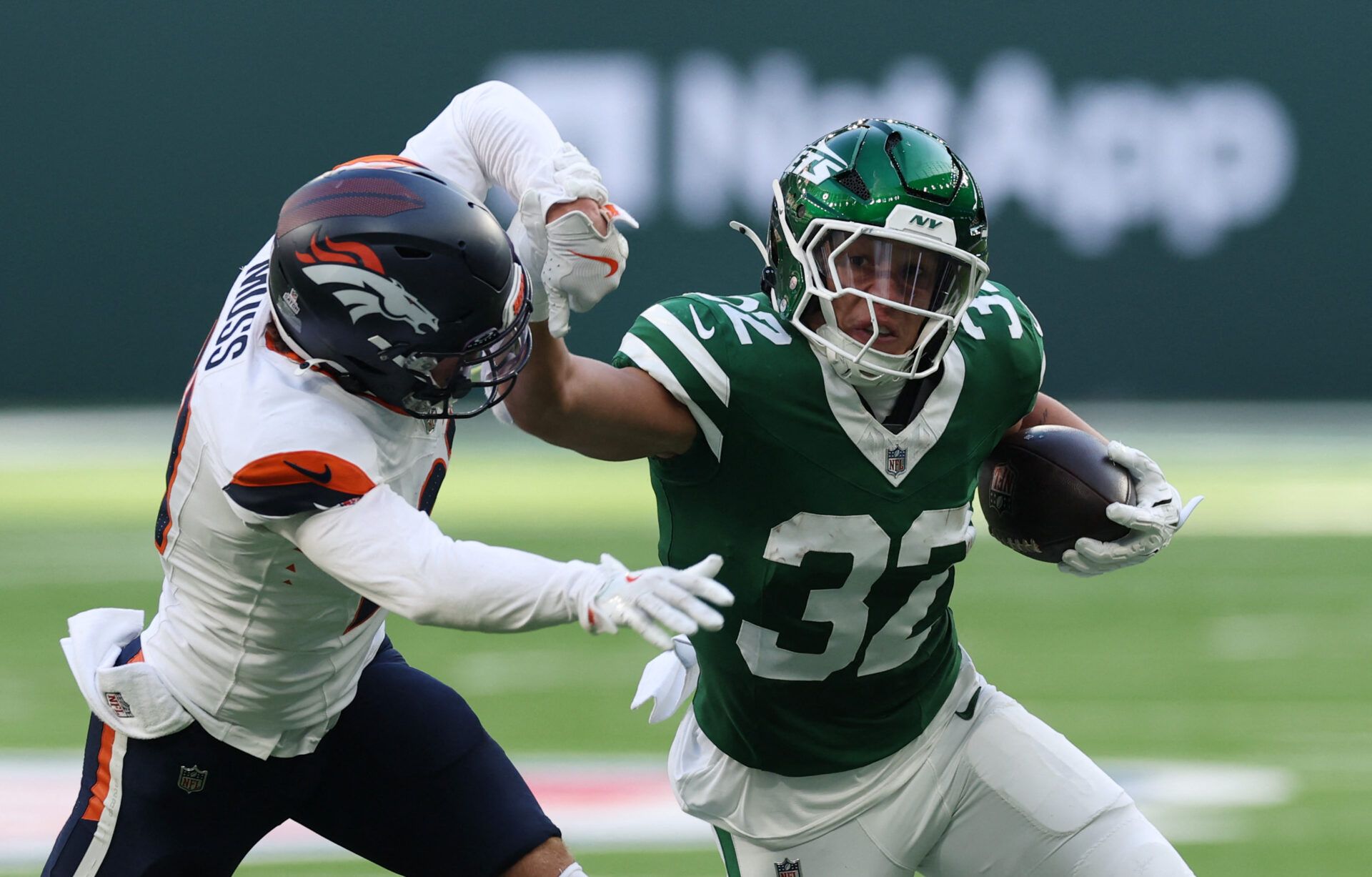 [US, Mexico & Canada customers only] Oct 12, 2025; Tottenham, UNITED KINGDOM;  New York Jets running back Isaiah Davis (32) runs against Denver Broncos defender Riley Moss  during an NFL International Series game at Tottenham Hotspur Stadium.