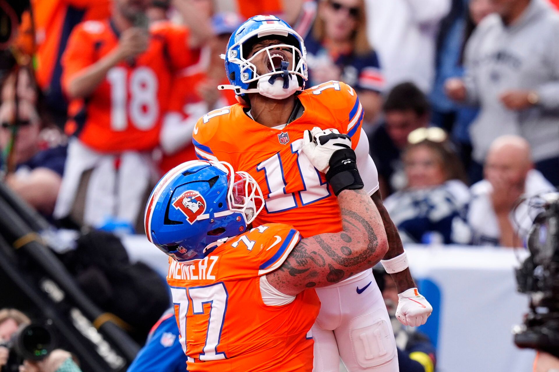 Denver Broncos wide receiver Troy Franklin (11) celebrates with guard Quinn Meinerz (77) after scoring touchdown against the Dallas Cowboys in the fourth quarter at Empower Field at Mile High.