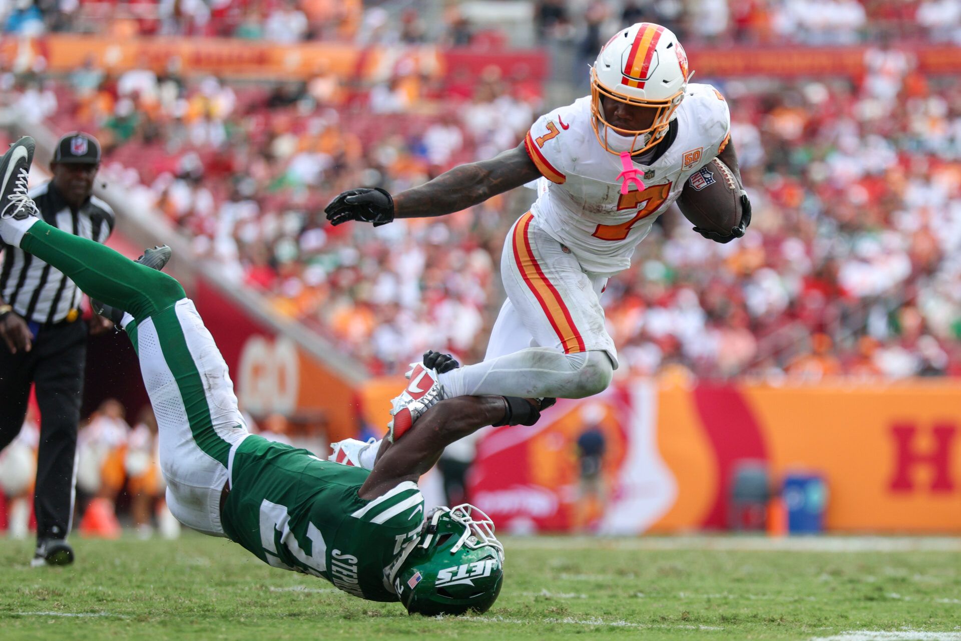 Tampa Bay Buccaneers running back Bucky Irving (7) is tripped up by New York Jets cornerback Brandon Stephens (21) in the third quarter  at Raymond James Stadium.