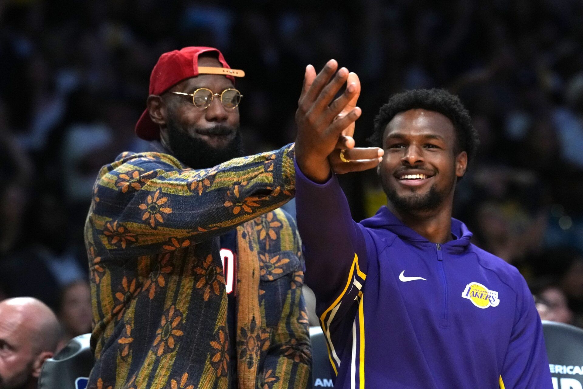 Los Angeles Lakers forward LeBron James (left) and son Bronny James  watch from the bench in the second half against the Minnesota Timberwolves at Crypto.com Arena.